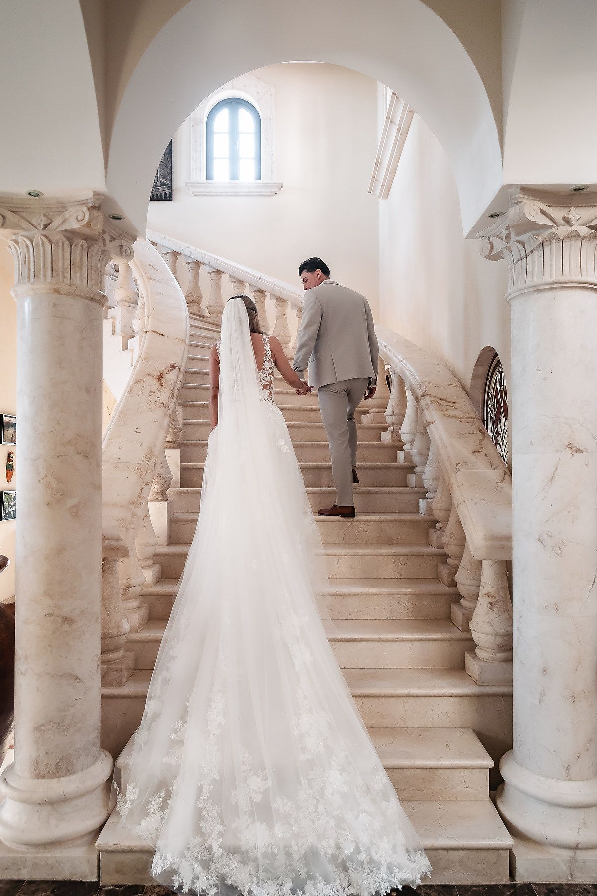 Wedding photography session on a grand white marble staircase with ornate architectural details.