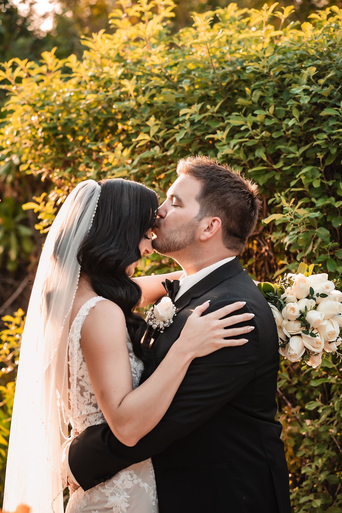 Romantic wedding moment captured against golden autumn foliage at sunset.