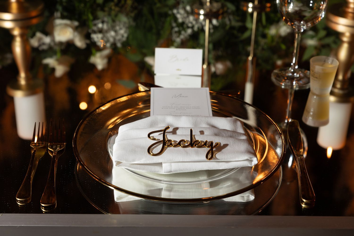 Elegant place settings and glowing candles create a romantic ambiance at an upscale restaurant table.