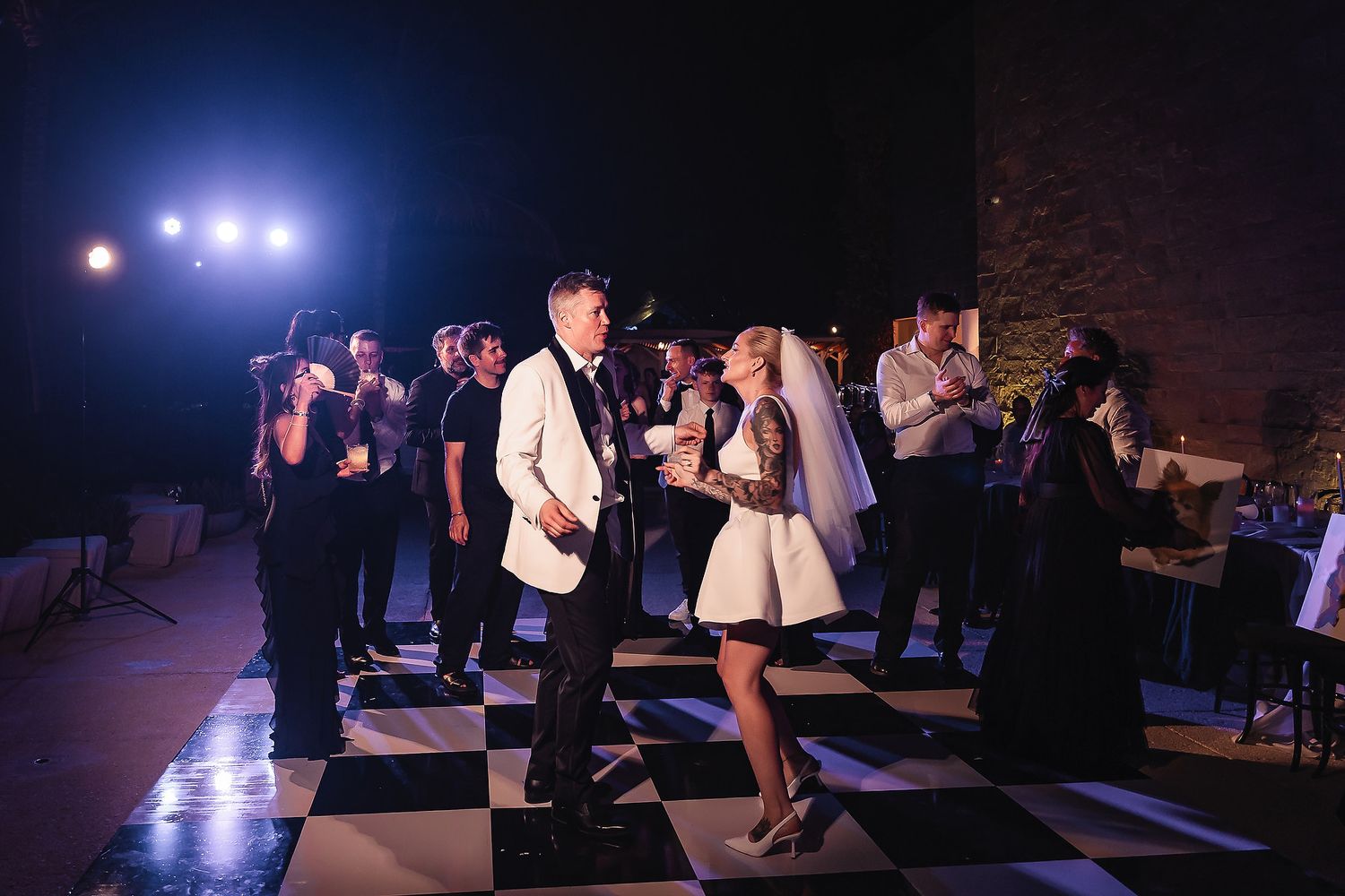Wedding reception dance floor with blue lighting and guests celebrating.