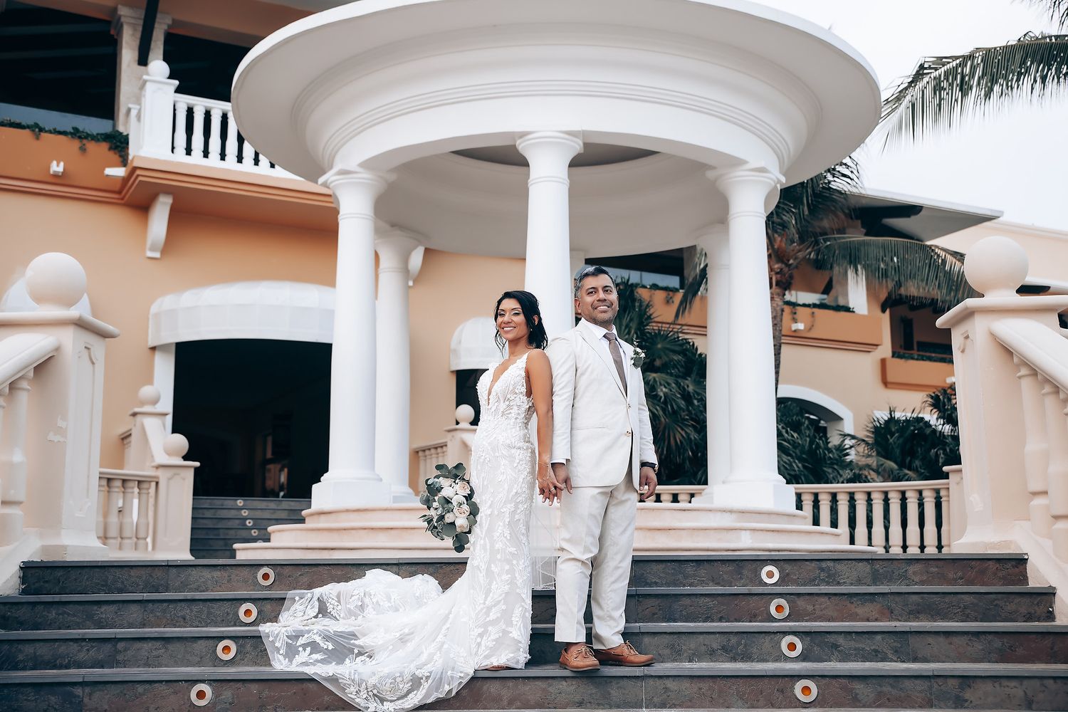 An elegant wedding photoshoot at a white columned venue with architectural details.