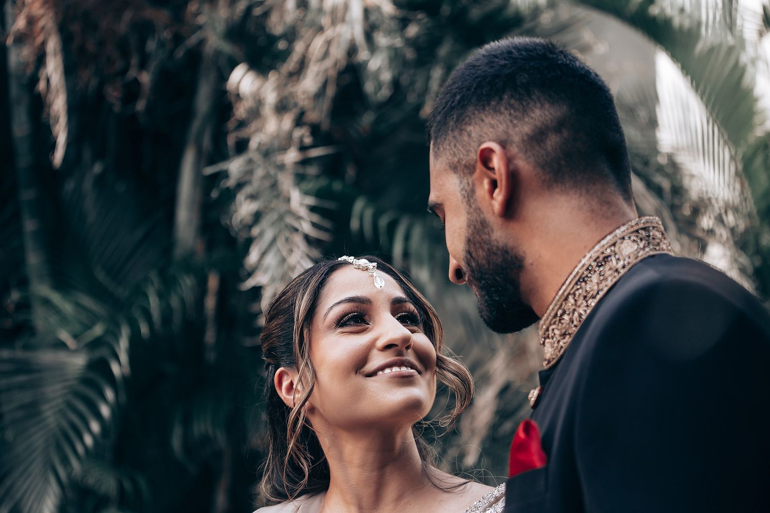 Romantic outdoor photoshoot with palm trees and natural lighting.
