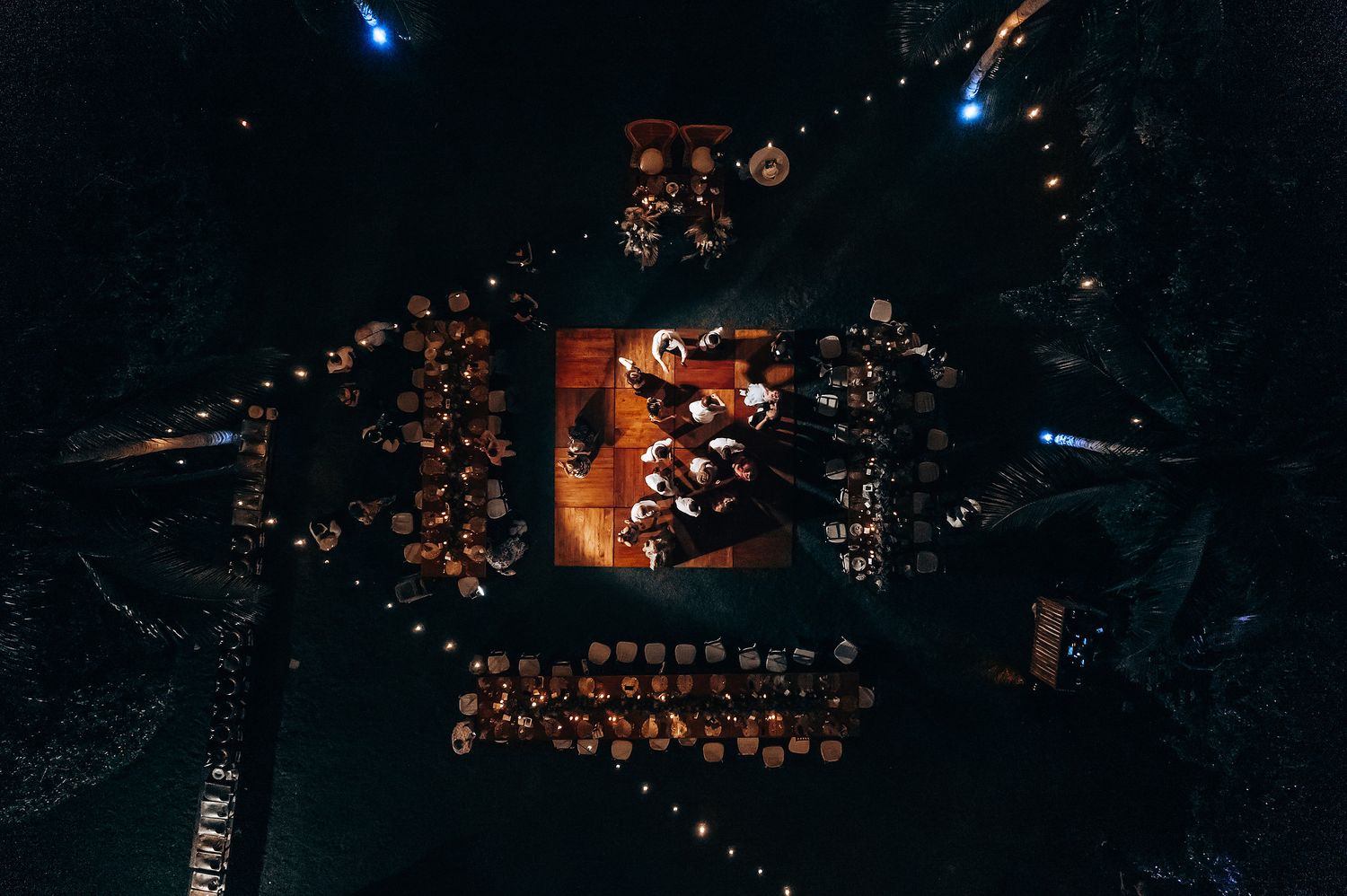 Wedding reception venue illuminated with romantic string lights and ambient lighting.