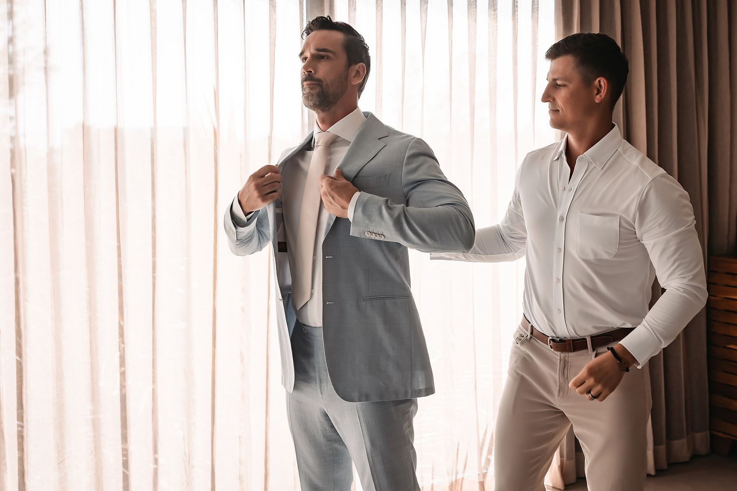 People in formal wear greeting each other in an indoor setting.