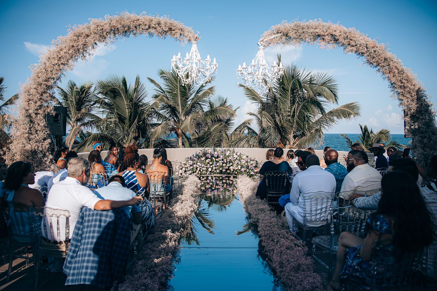 A beachside wedding ceremony setup with a floral arch and ocean views.