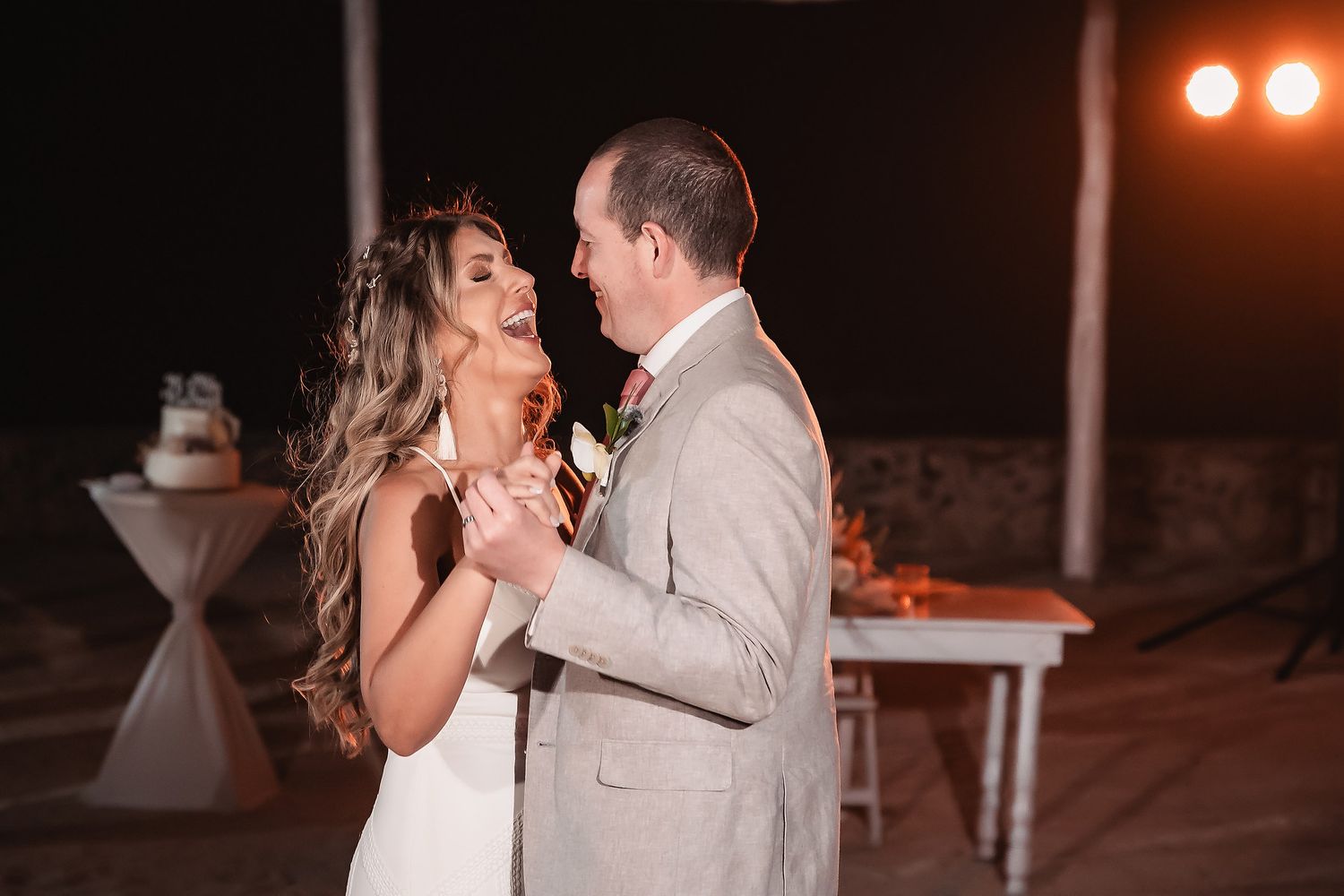 Wedding reception dance under warm string lights creating an intimate atmosphere.