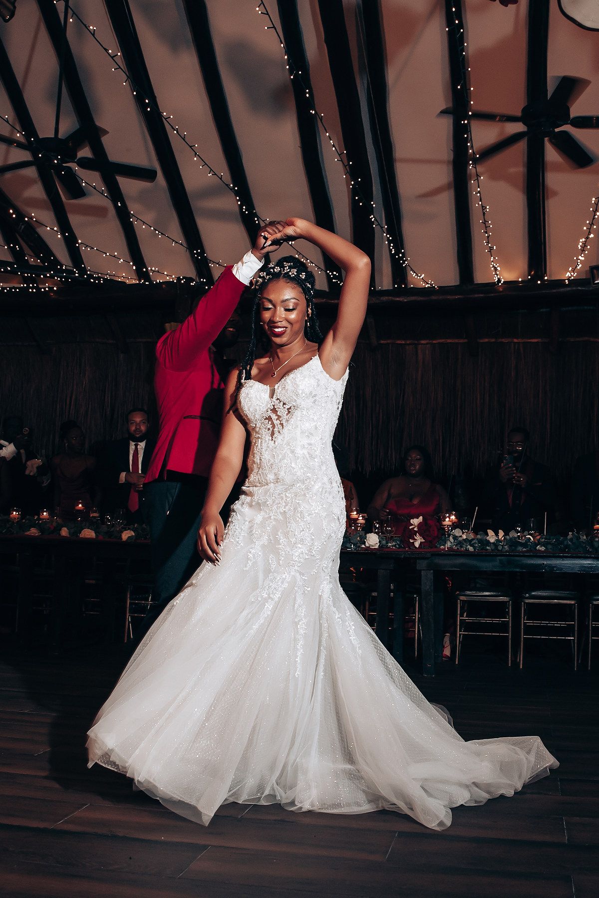 A bride in a white ballgown twirls gracefully on the dance floor during a wedding reception.