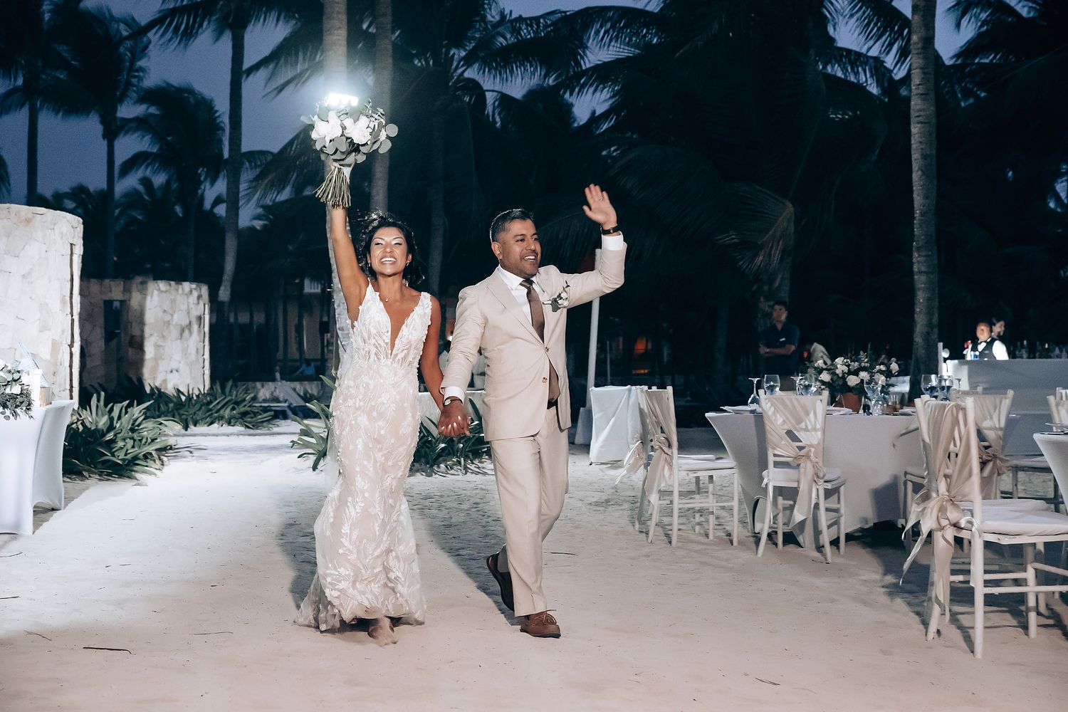 Wedding celebration at dusk with guests in formal attire mingling on an outdoor terrace.