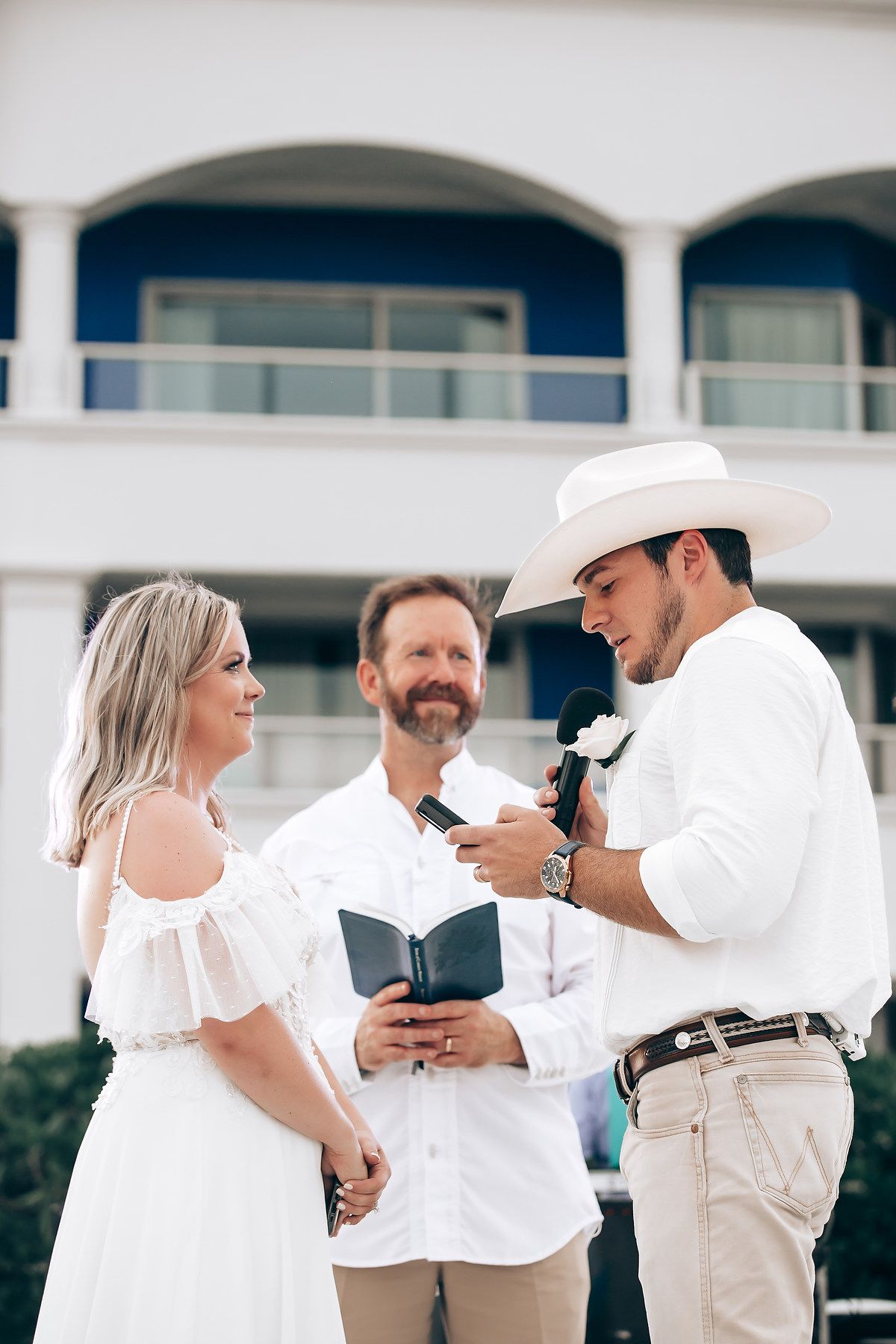 Couples dancing together at an outdoor venue wearing coordinated white and beige outfits.