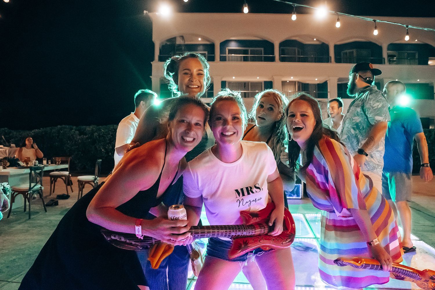 People enjoying a nighttime outdoor gathering with colorful LED lights creating a festive atmosphere.
