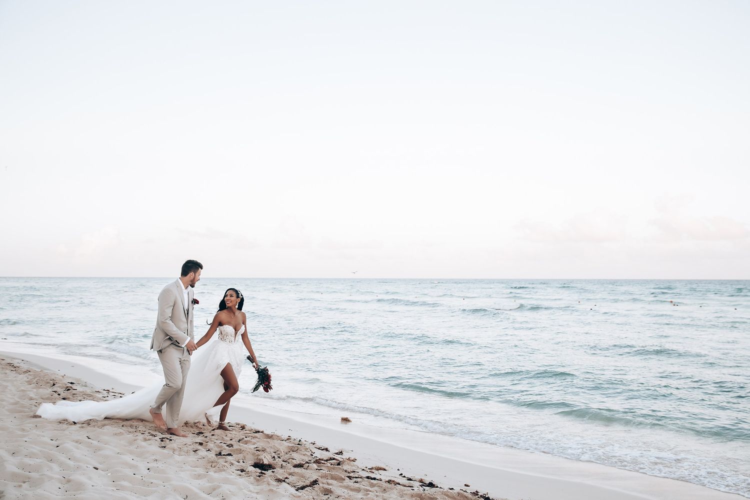 Romantic beach photoshoot with waves crashing in the background.