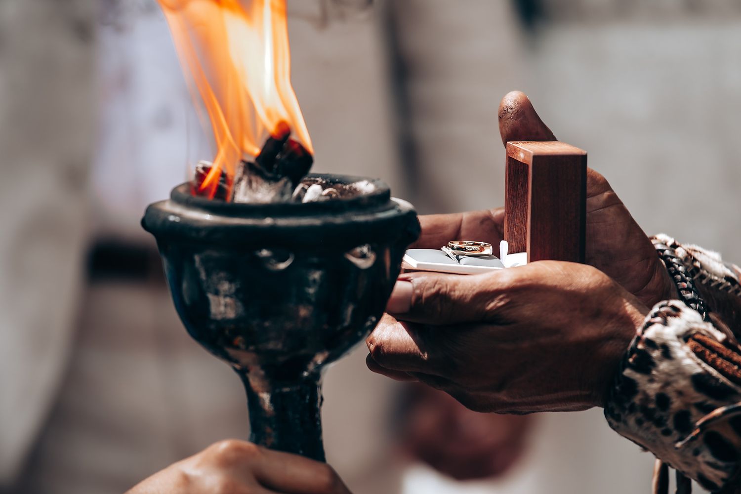 Traditional smoking ceremony ritual being performed with burning elements at an outdoor wedding.