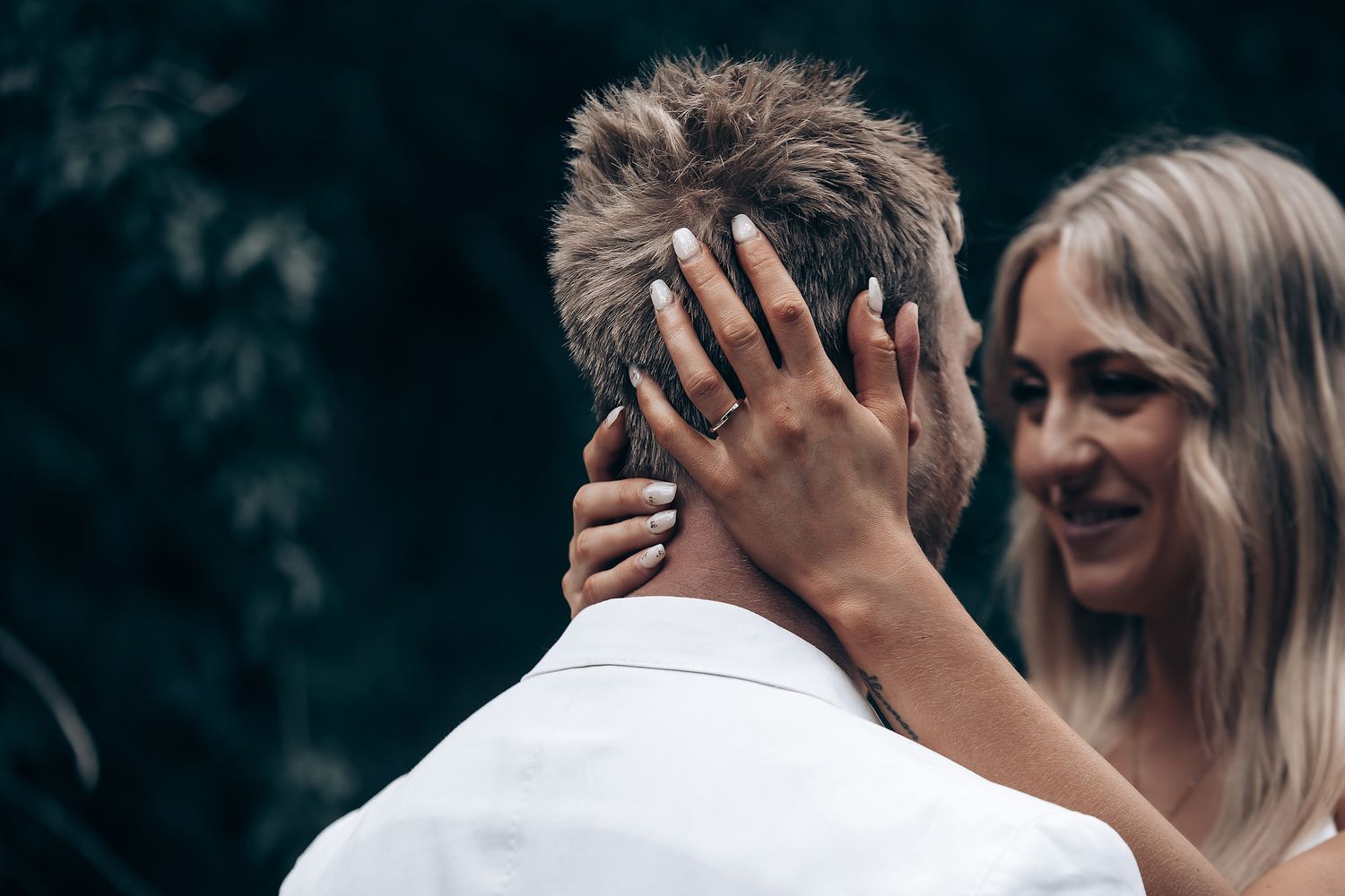 A candid moment between a couple during their forest wedding photoshoot.