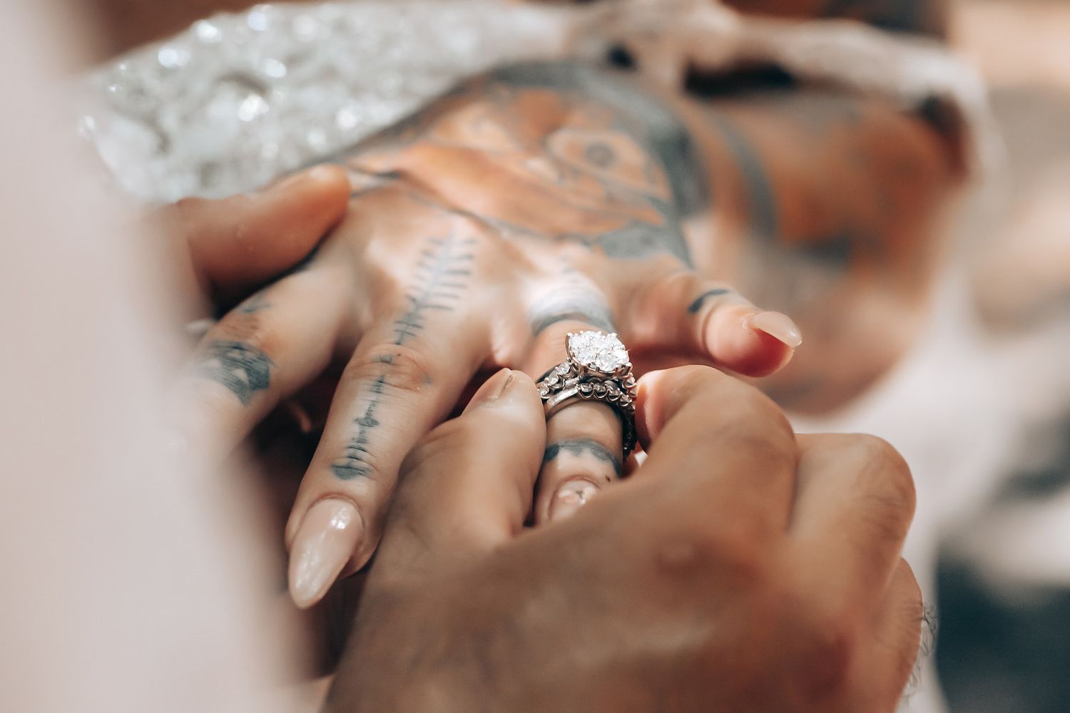 Detailed view of wedding rings being placed on fingers during ceremony.