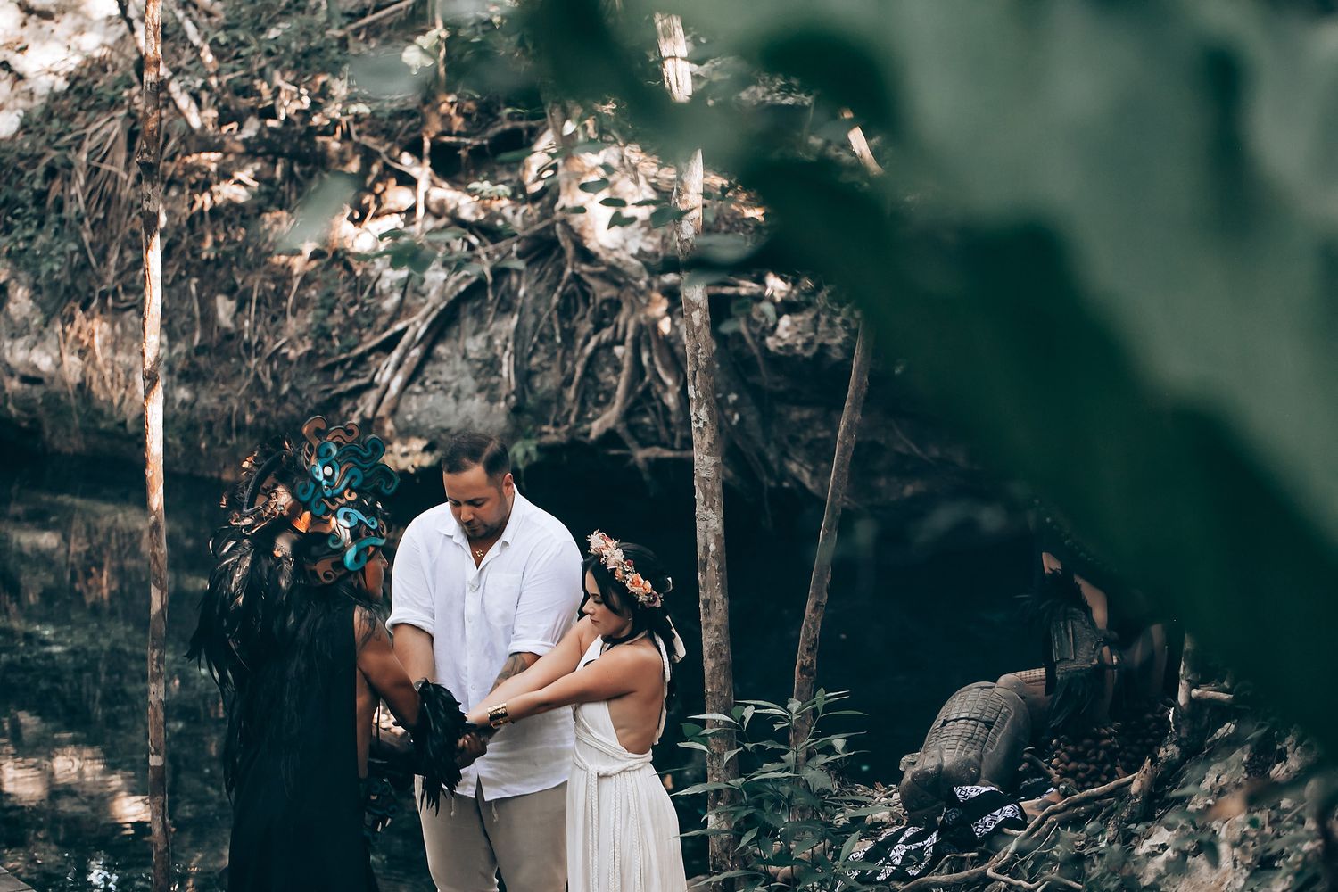 An intimate outdoor ceremony unfolds in a serene forest setting with traditional elements.