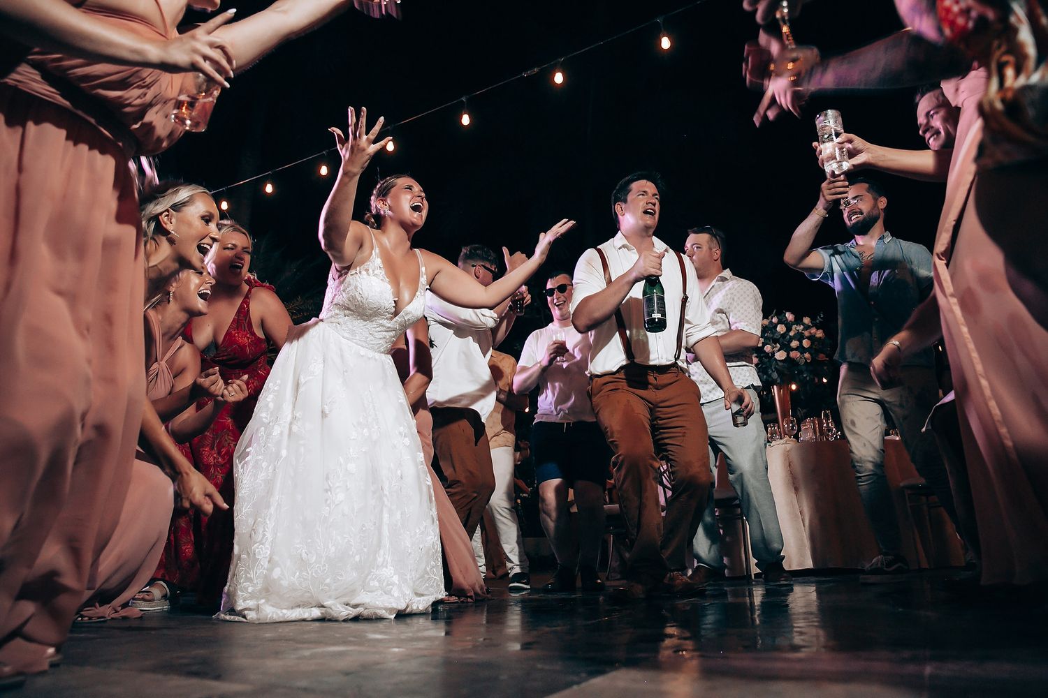 Wedding party dancing and celebrating with live music at a lively reception.