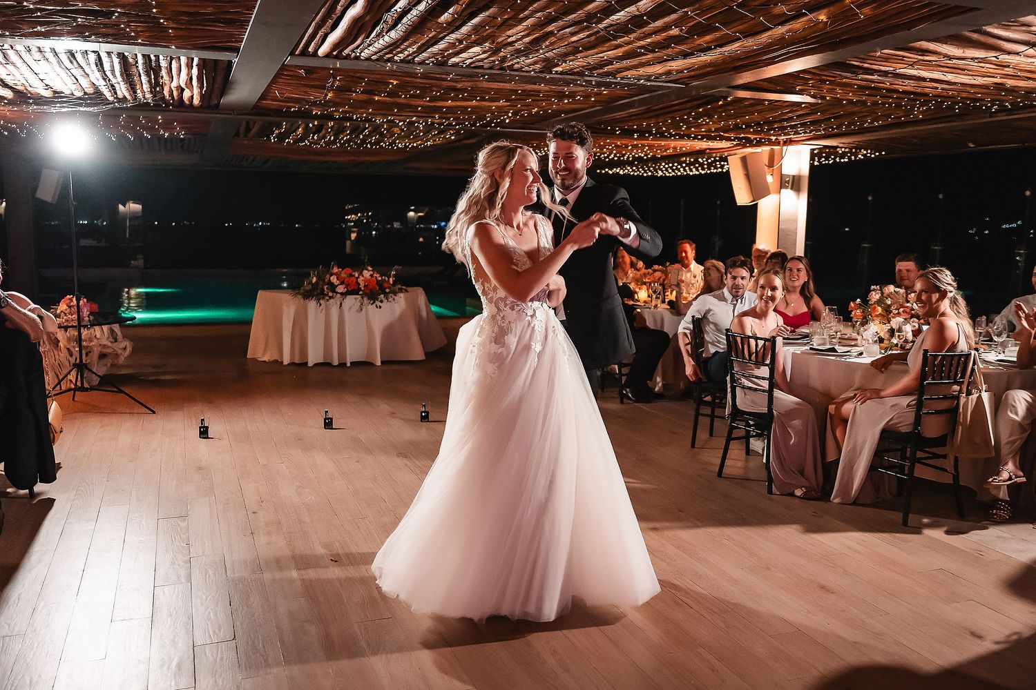 Wedding reception dance floor scene with string lights creating warm ambiance.