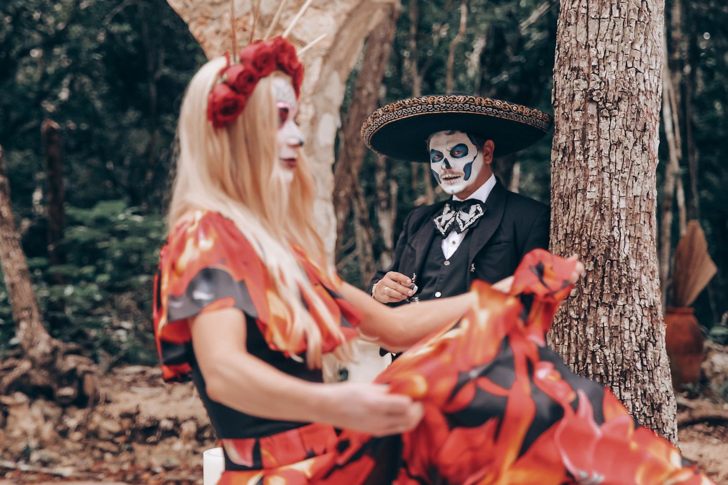 Artistic Halloween-themed photo series in a forest setting featuring a flowing red dress and gothic styling.