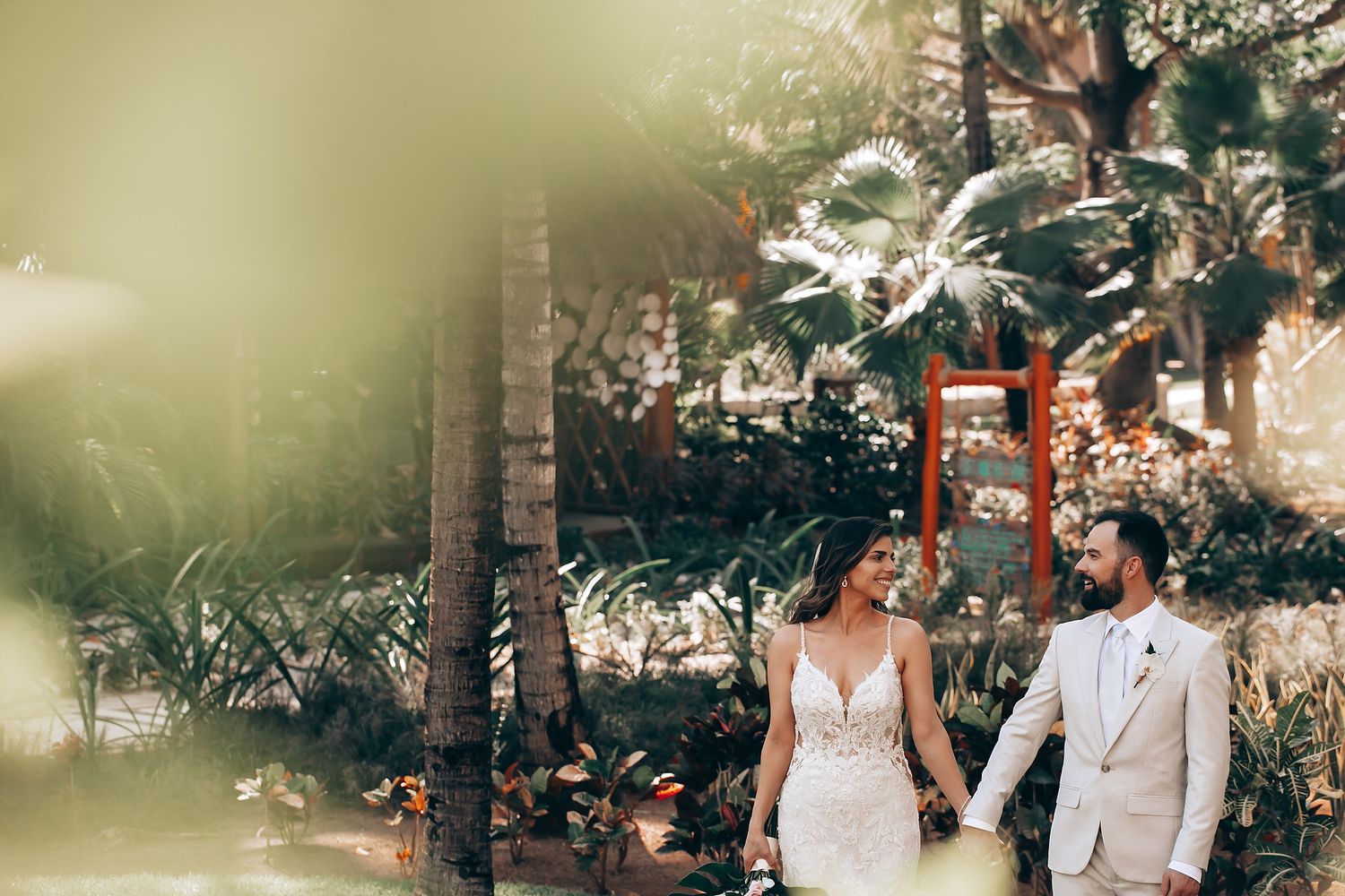 Elegant outdoor wedding ceremony with floral arrangements and palm trees in the background.