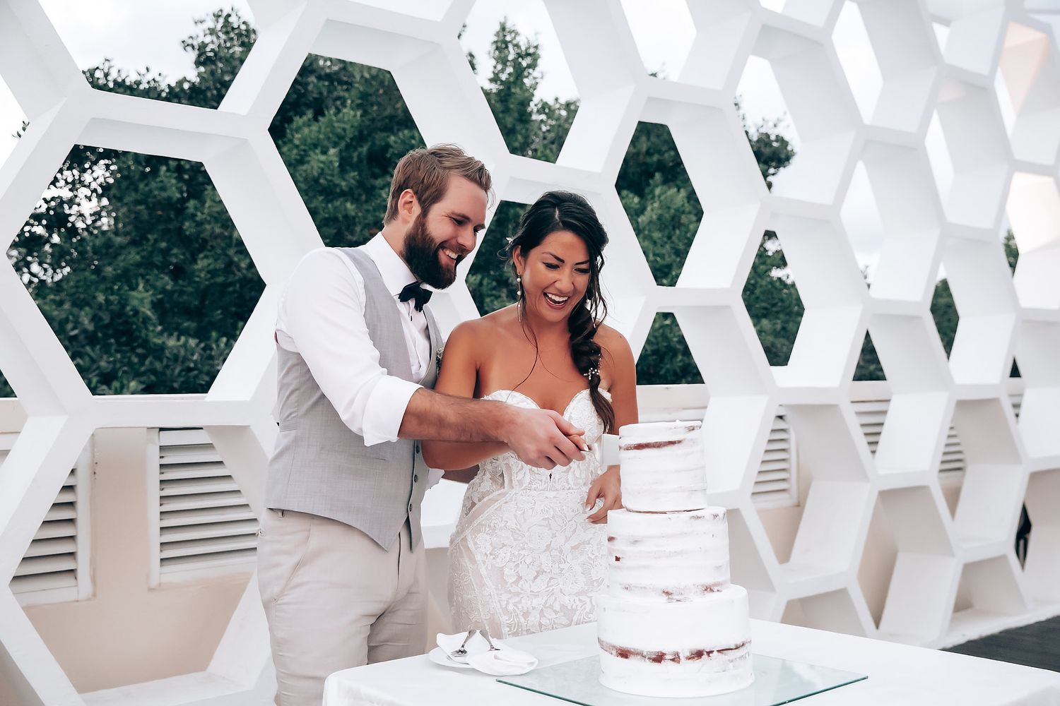 Modern white hexagonal wall design creates geometric patterns at an outdoor wedding venue.