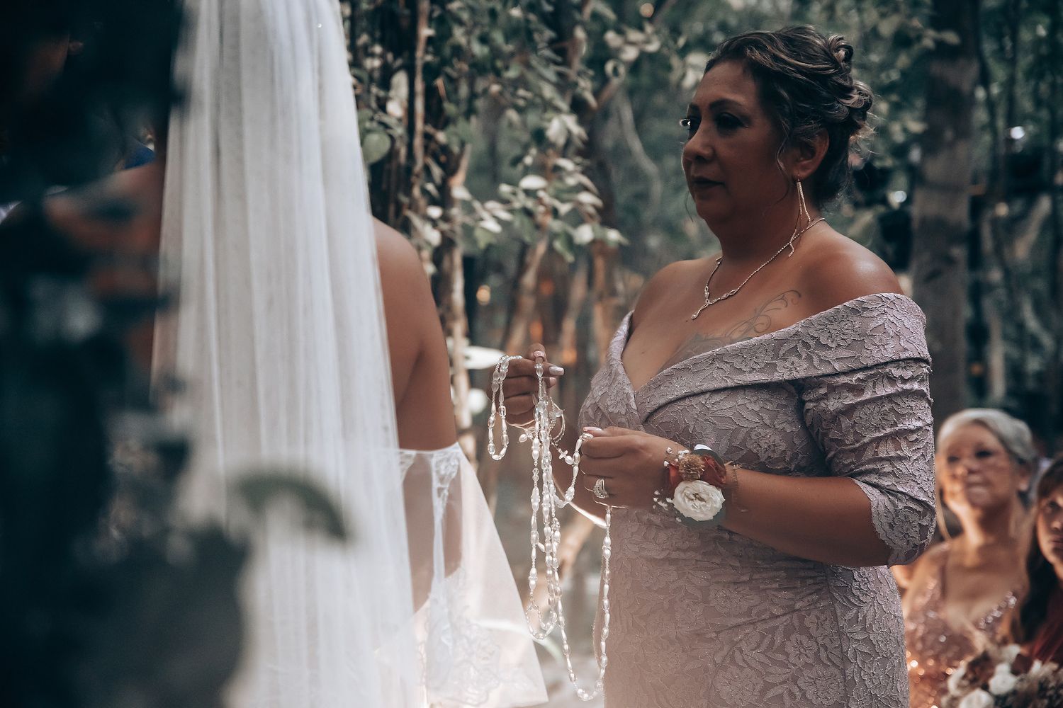 An intimate outdoor wedding ceremony moment captured in a wooded setting.