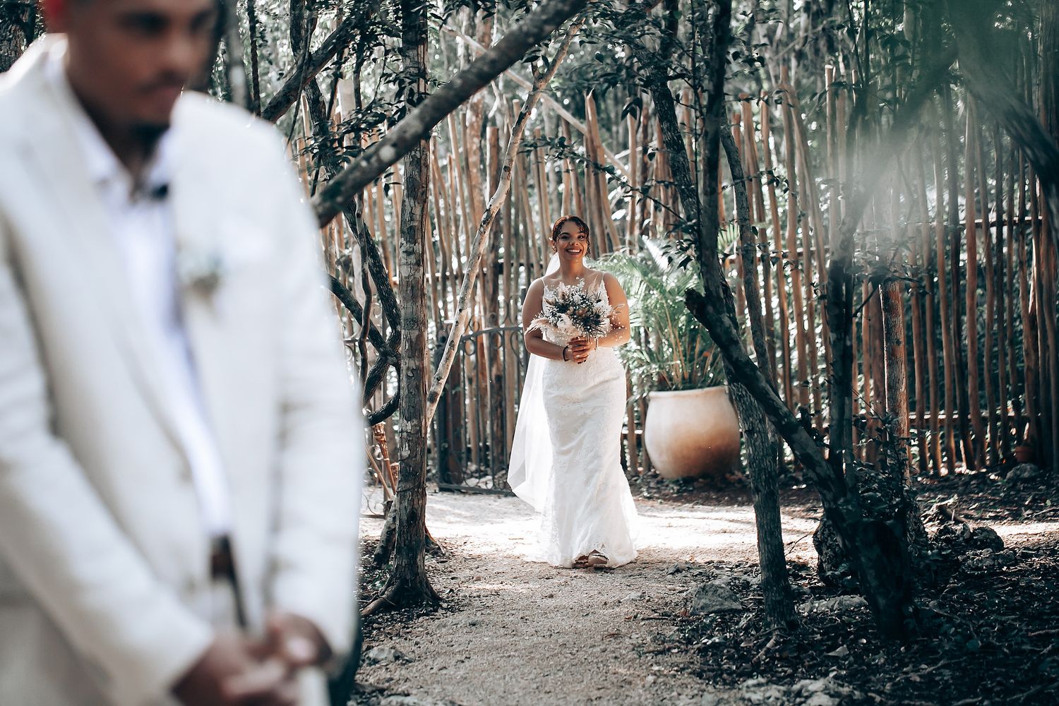 A wedding photoshoot in a rustic forest setting with soft natural lighting filtering through trees.