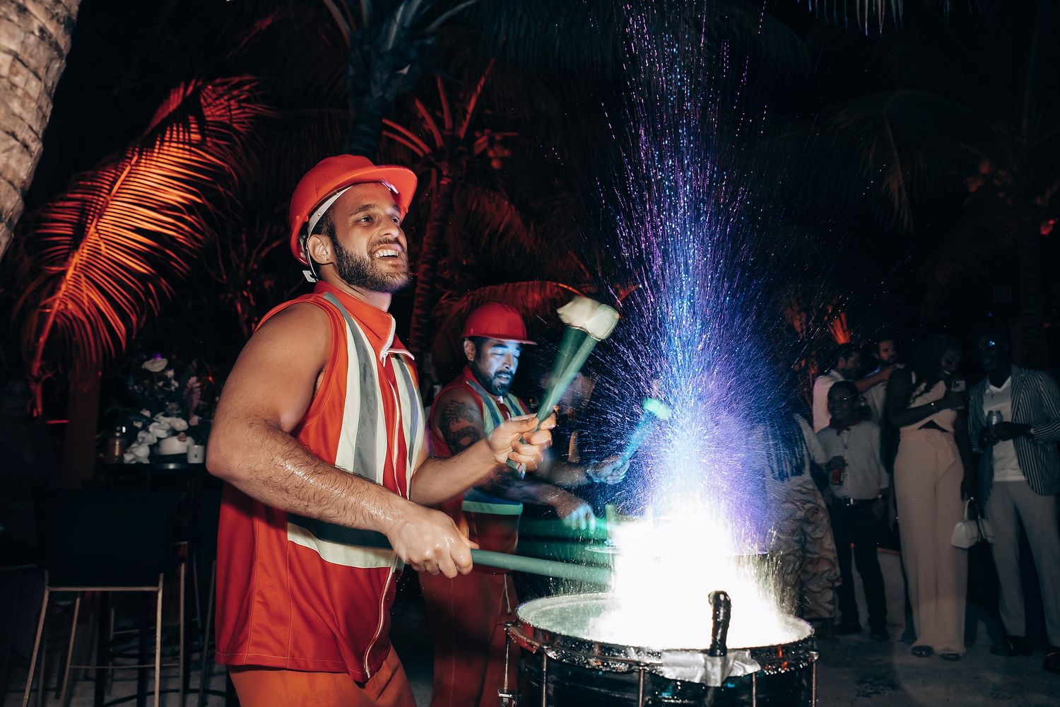 Performers with illuminated props creating dramatic light show effects at outdoor nighttime event.