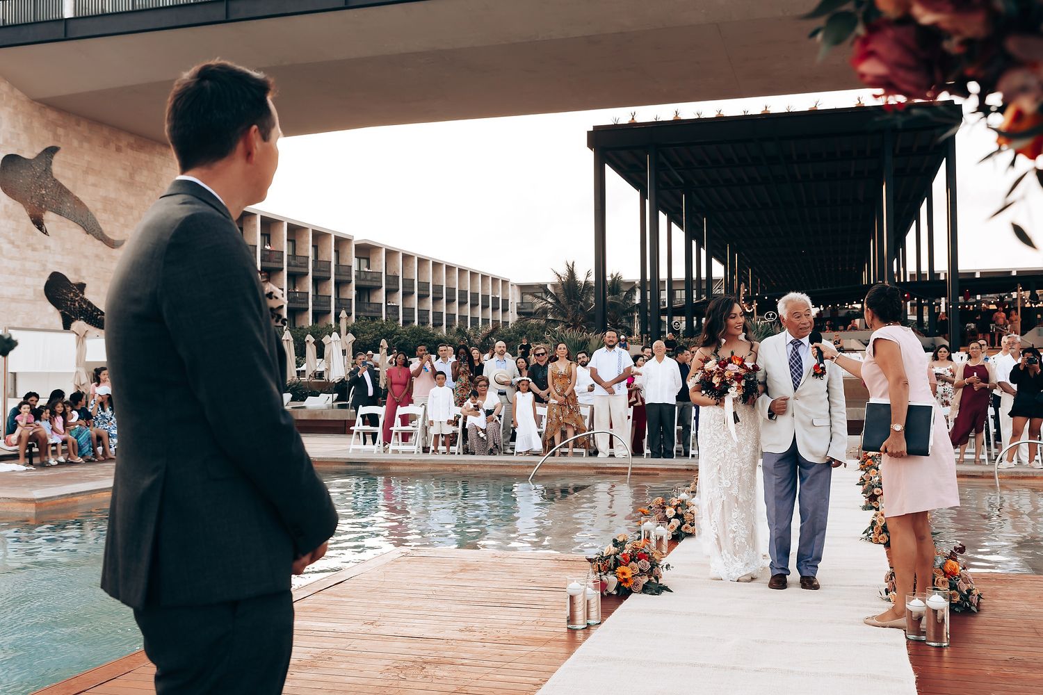 People mingle near a swimming pool at an upscale resort venue.