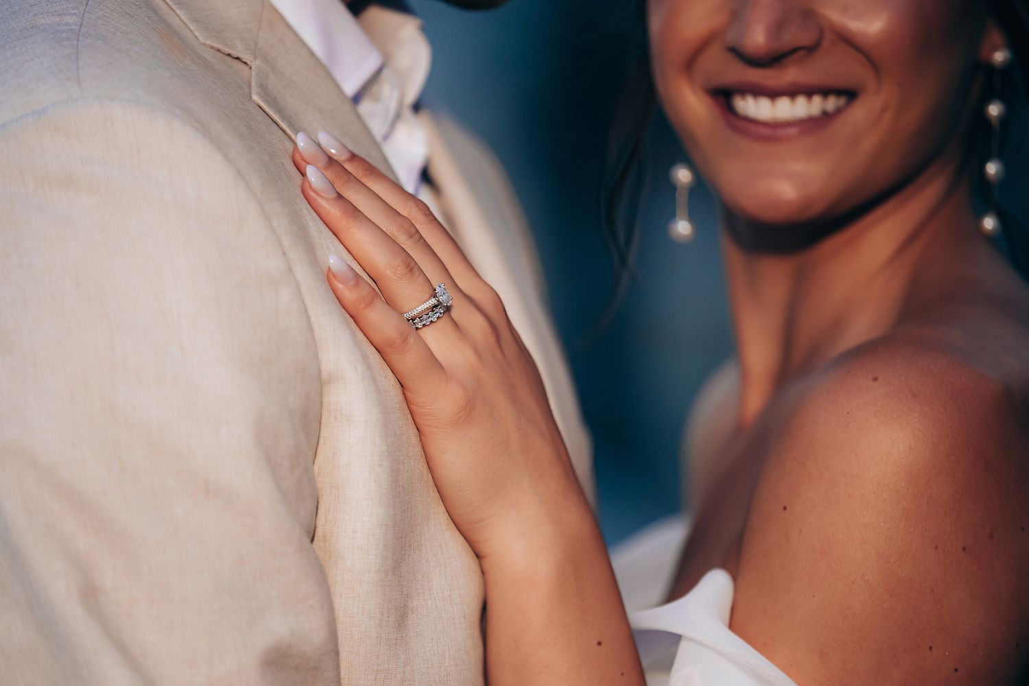 Close-up shot of hands showing off an engagement ring during a romantic wedding moment.