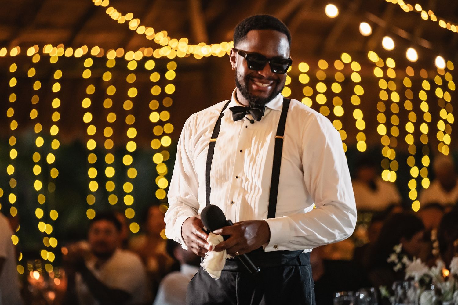 Wedding reception venue with warm golden string lights creating an intimate atmosphere.