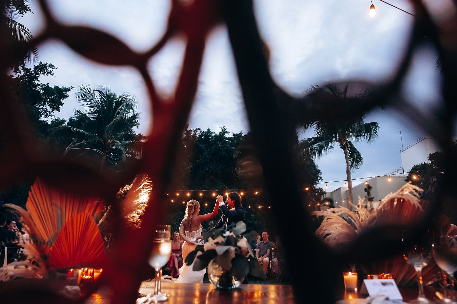 Evening wedding reception with string lights creating a magical outdoor ambiance.