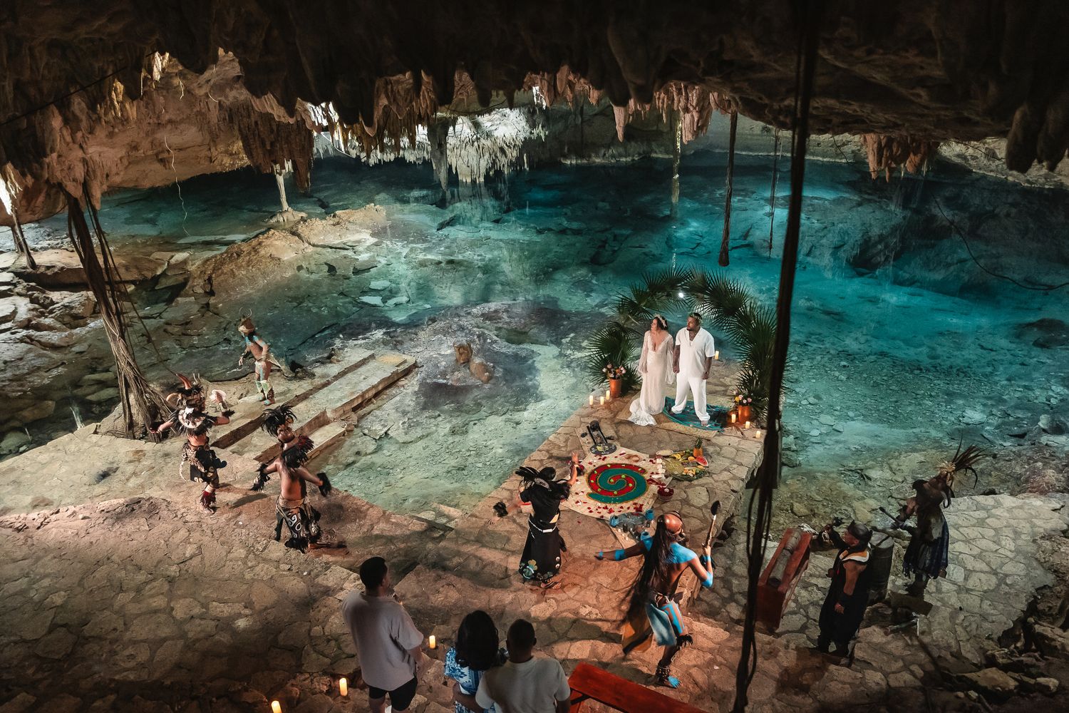 Wedding celebration in a majestic cave cenote with vibrant blue waters.