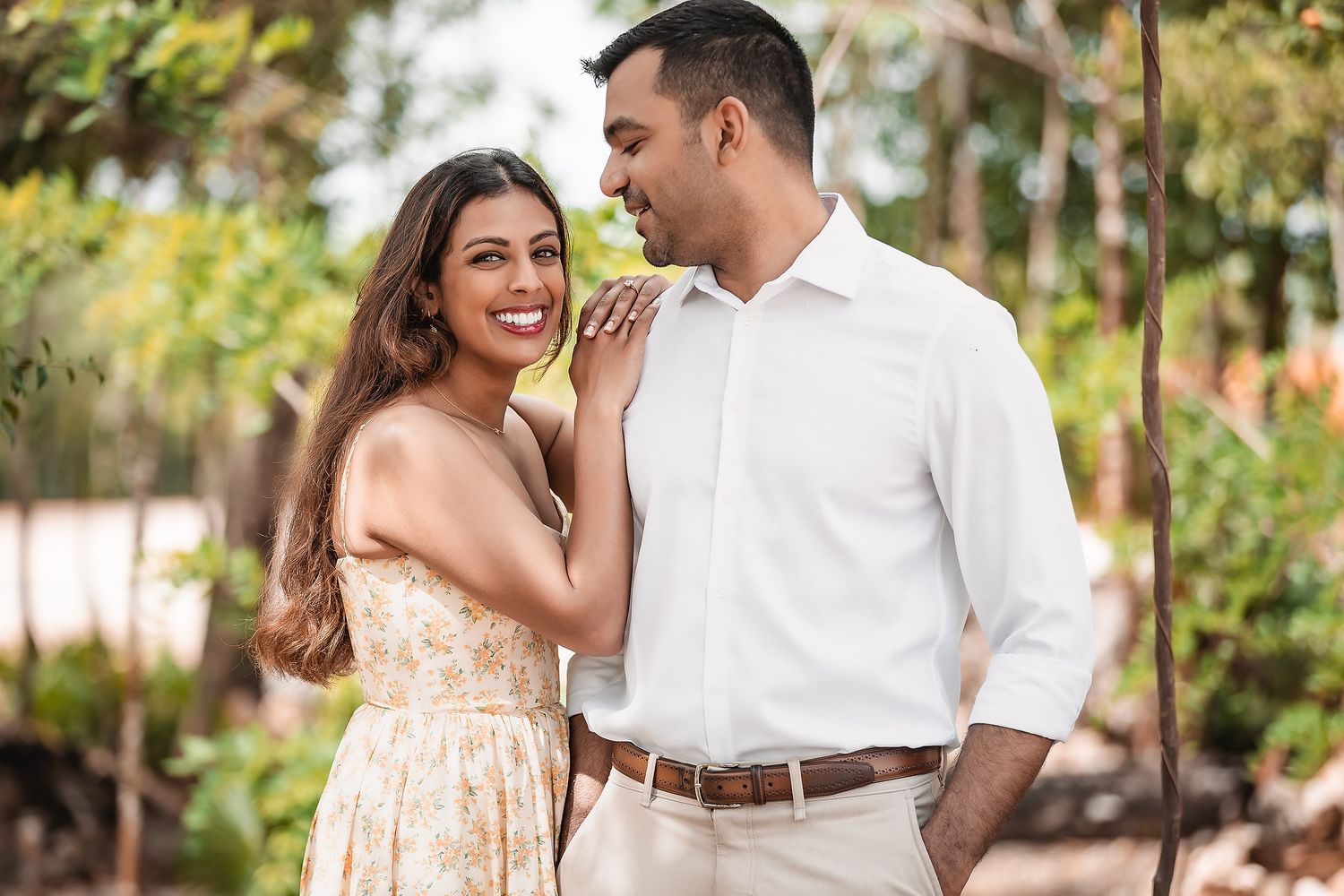 Couple shares joyful moment together in outdoor garden setting.