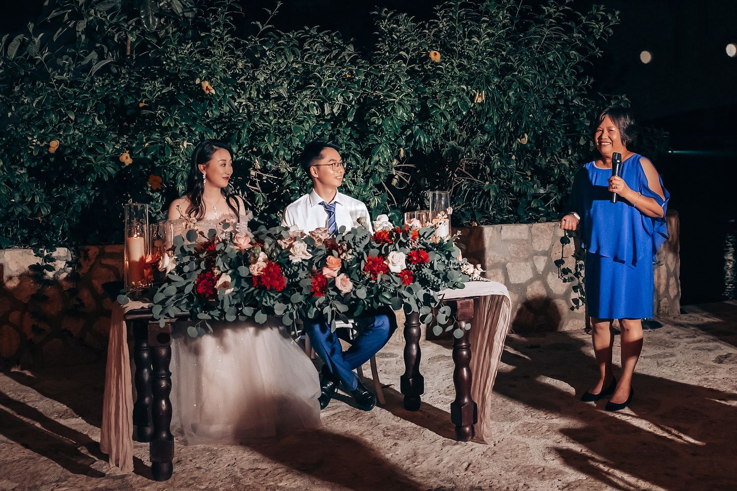 Wedding guests enjoying an outdoor evening celebration under garden lights.