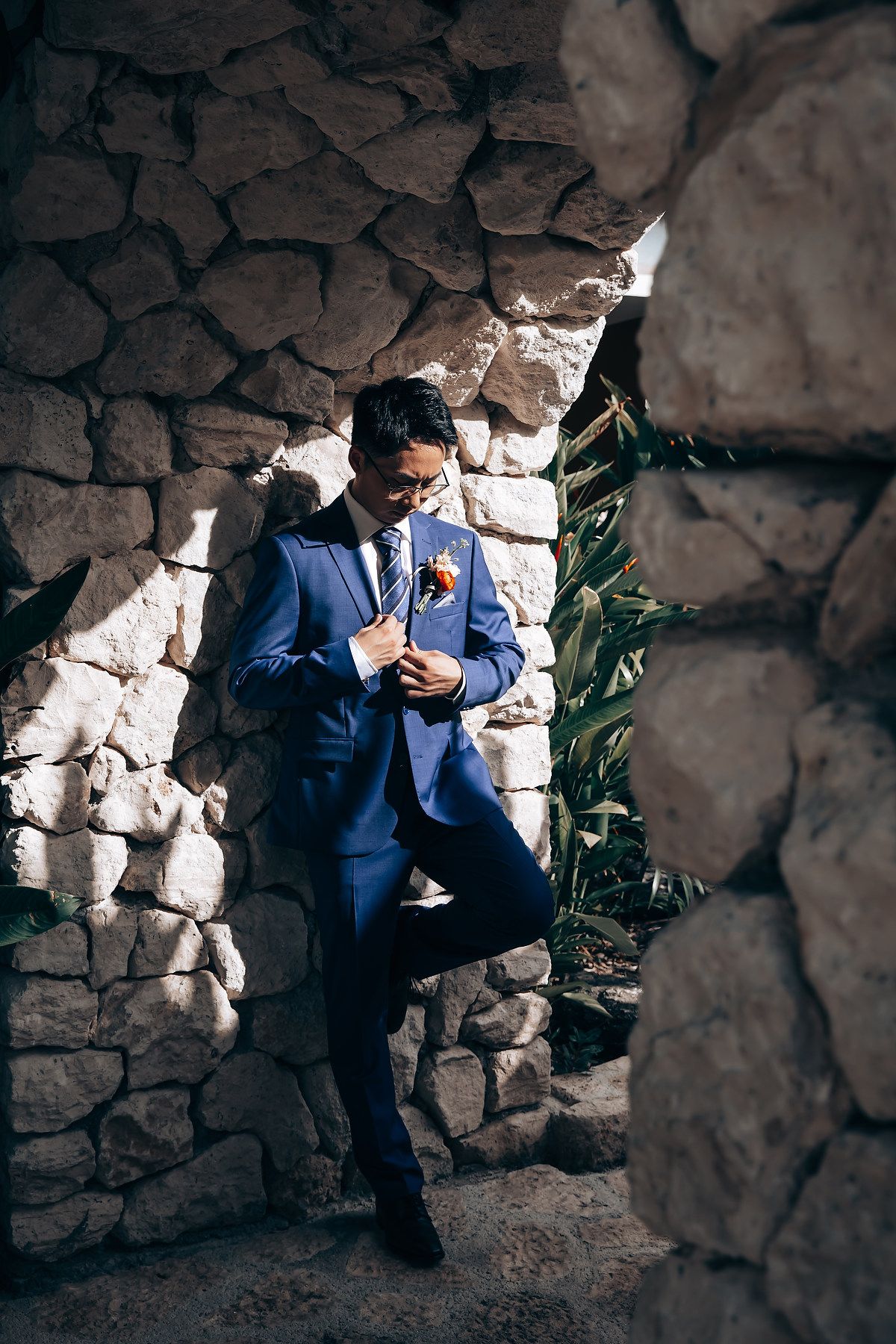 A series of emotional moments captured in a stone archway showing a person in a navy blue suit.