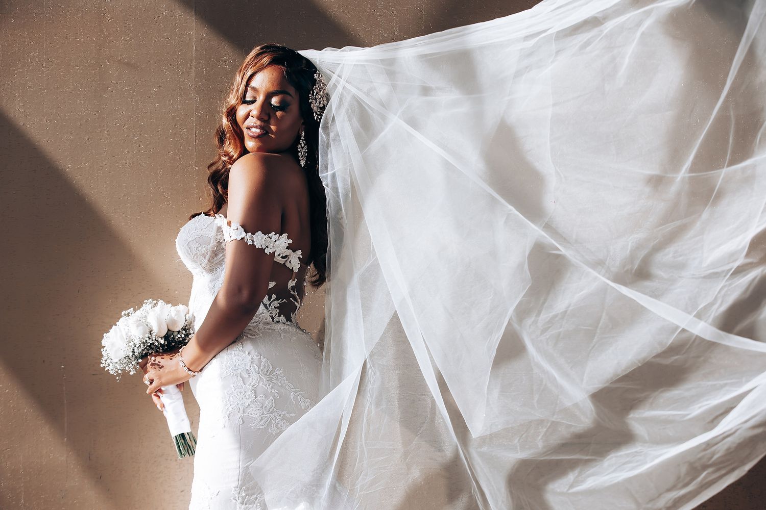 Dramatic bridal portraits showing flowing wedding gown with cathedral length train.
