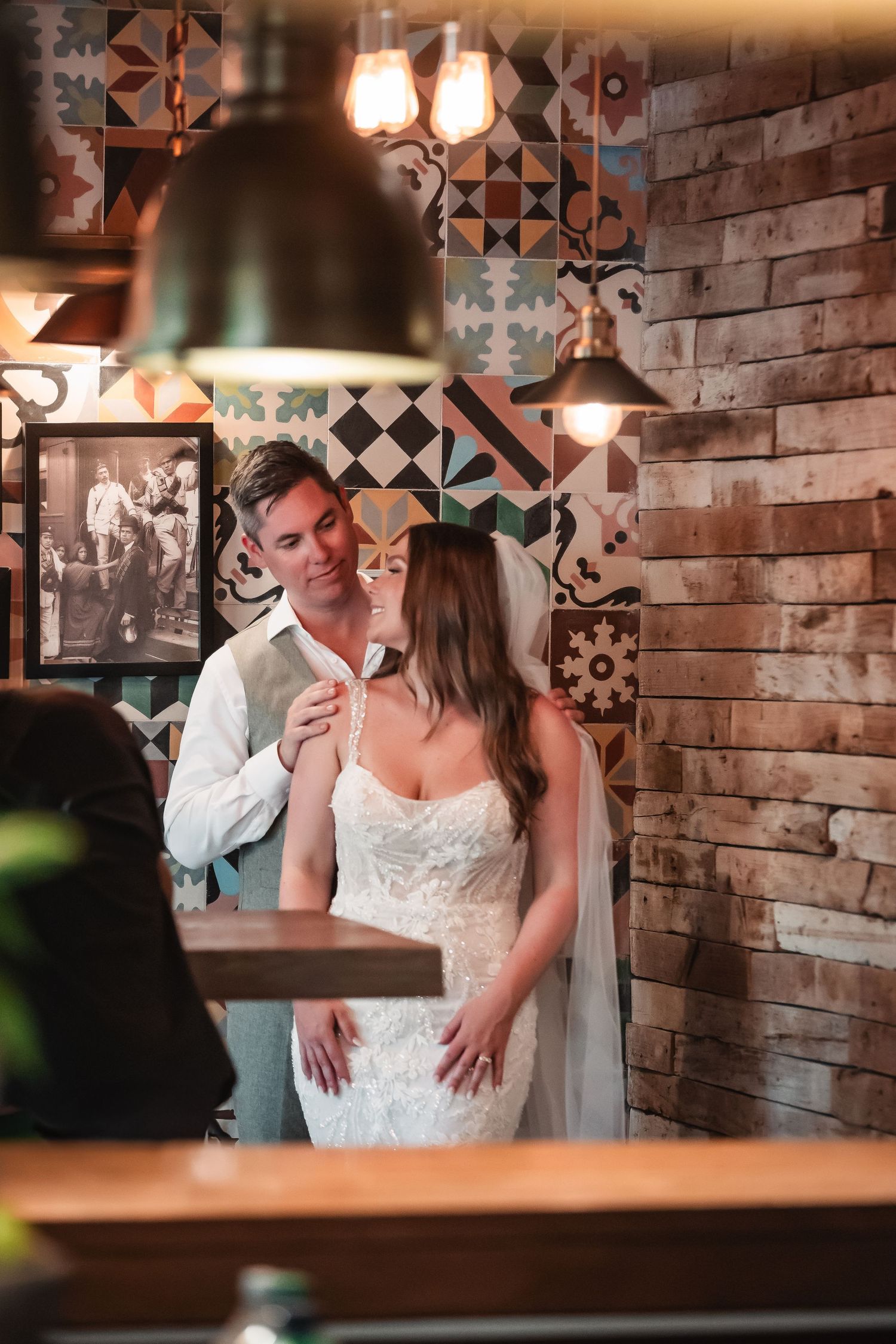 Intimate wedding moments captured against exposed brick walls and vintage-style lighting.