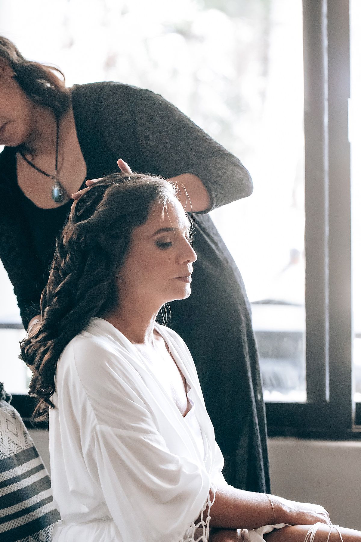 Preparation scene in a bright room with white robes and styling tools.