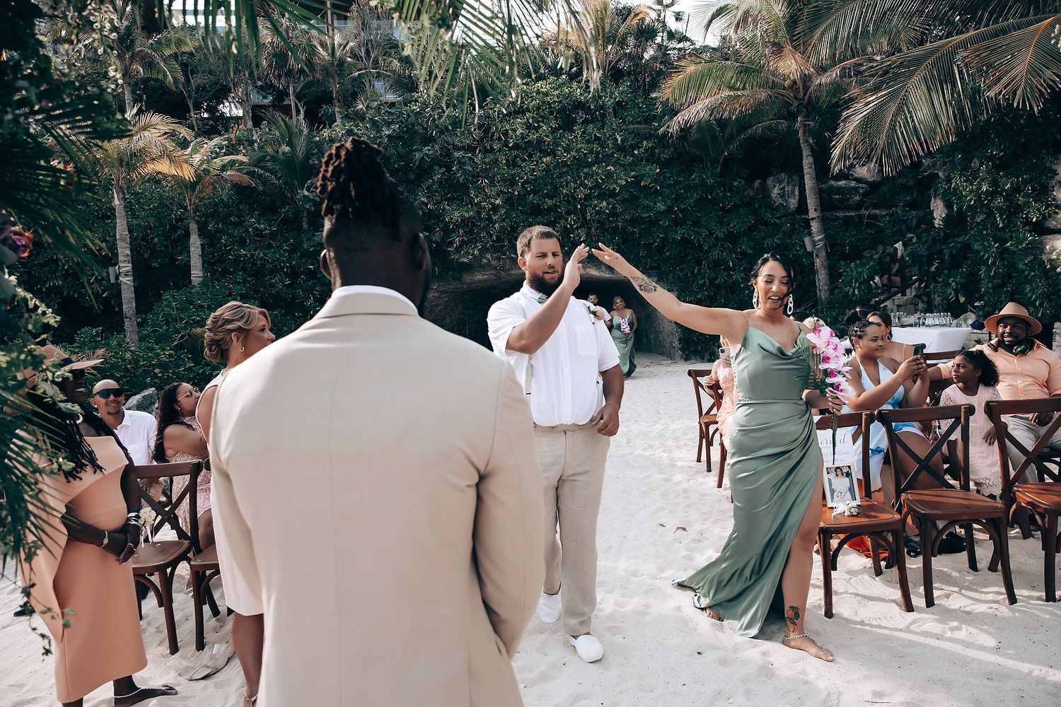 Wedding party celebrating outdoors at a tropical beach venue.