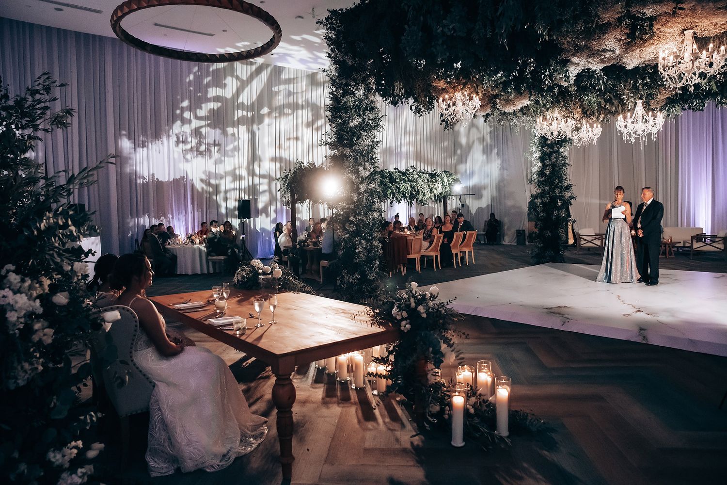 Luxurious wedding venue setup with chandeliers and ambient lighting creating a romantic atmosphere.