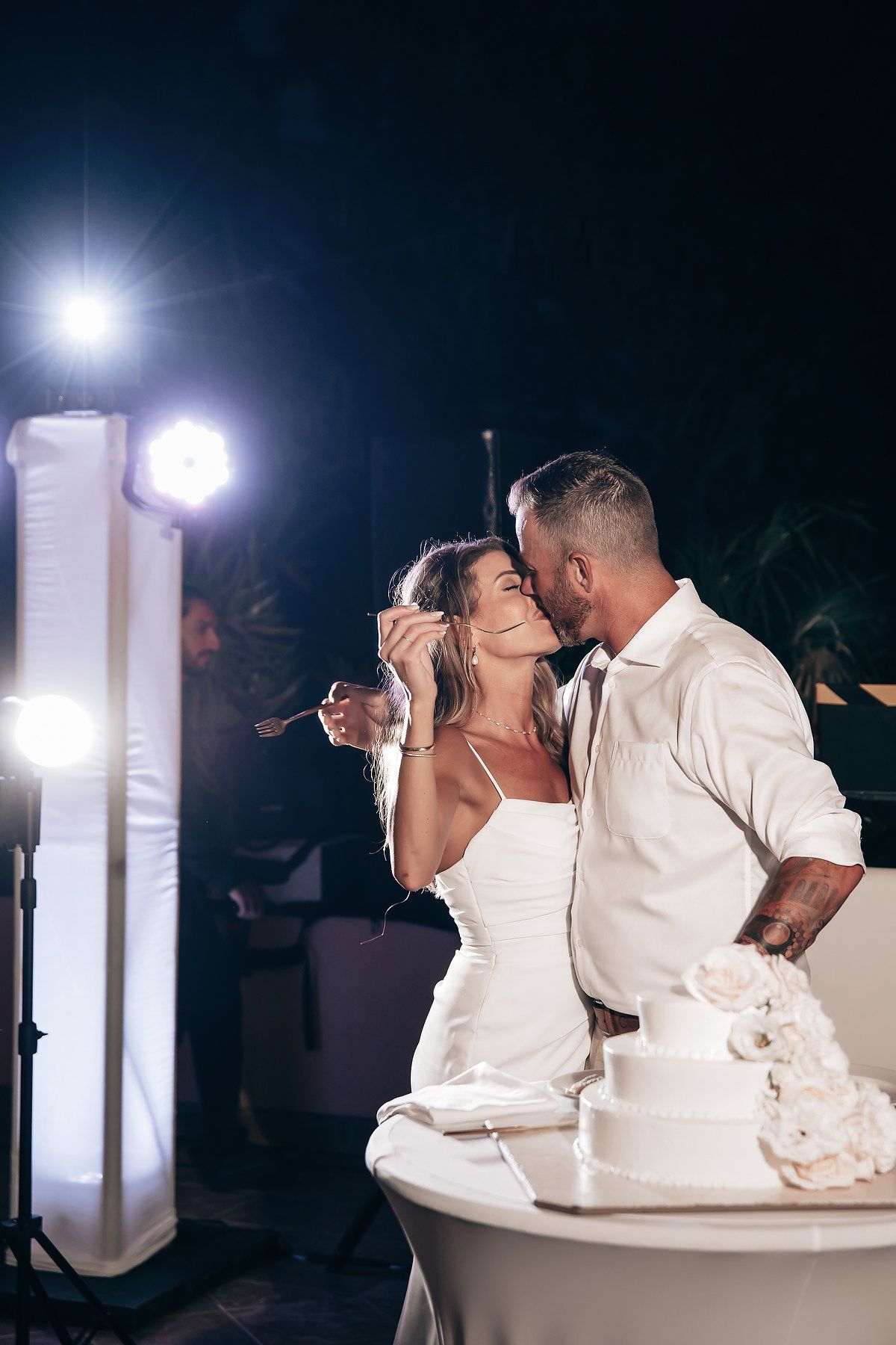A bride and groom share a romantic dance under the lights at their wedding reception.