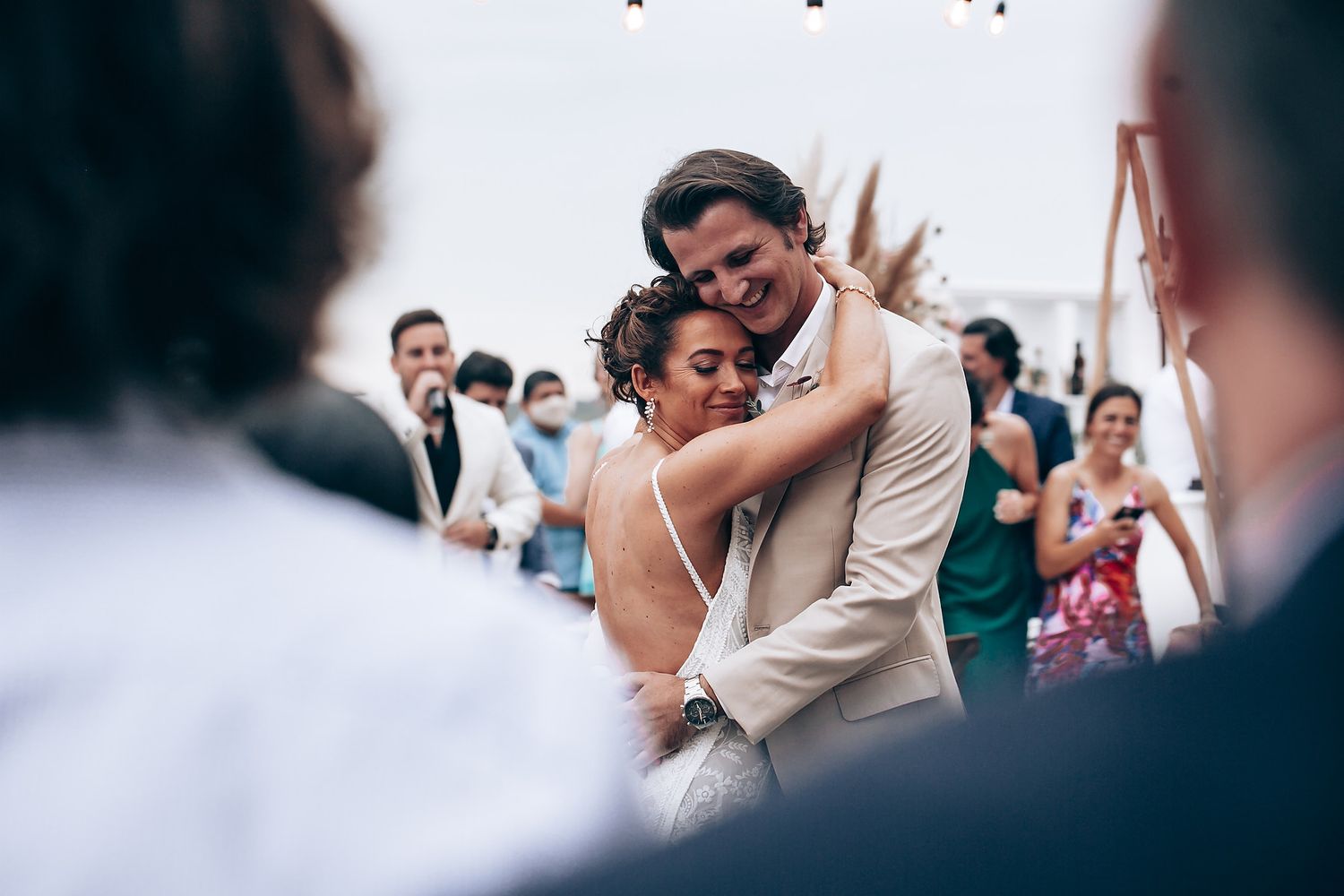 Wedding celebration moment captured with guests clapping in a dimly lit venue setting.