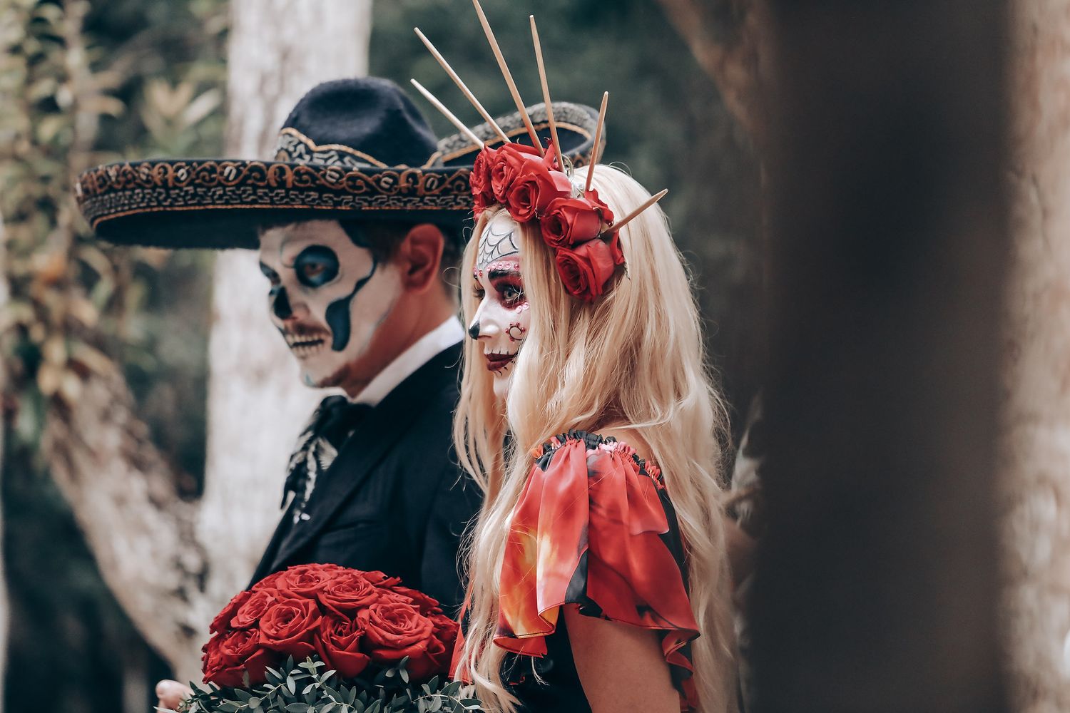 Dramatic outdoor scene with red roses and gothic-styled accessories in a forest setting.