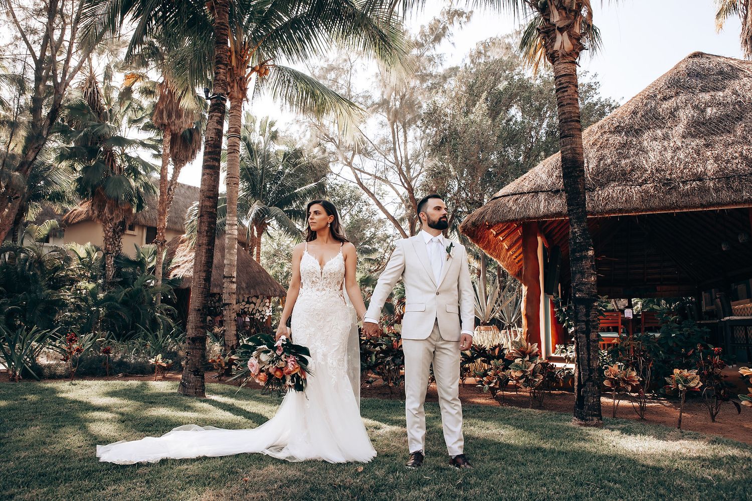 Outdoor wedding portraits in a tropical garden setting with palm trees.
