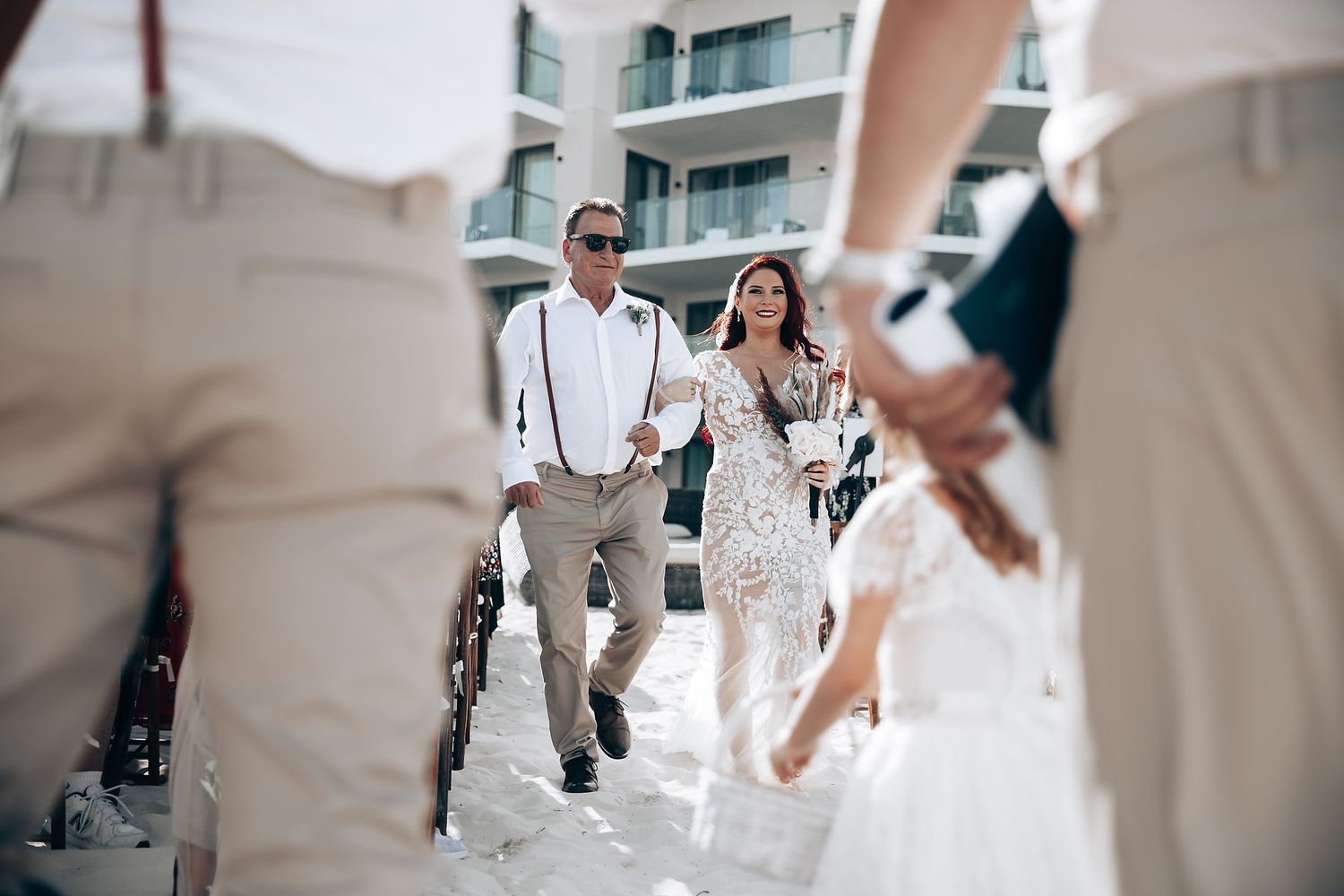 Wedding celebration candid moments captured on a sunny beach with resort backdrop.