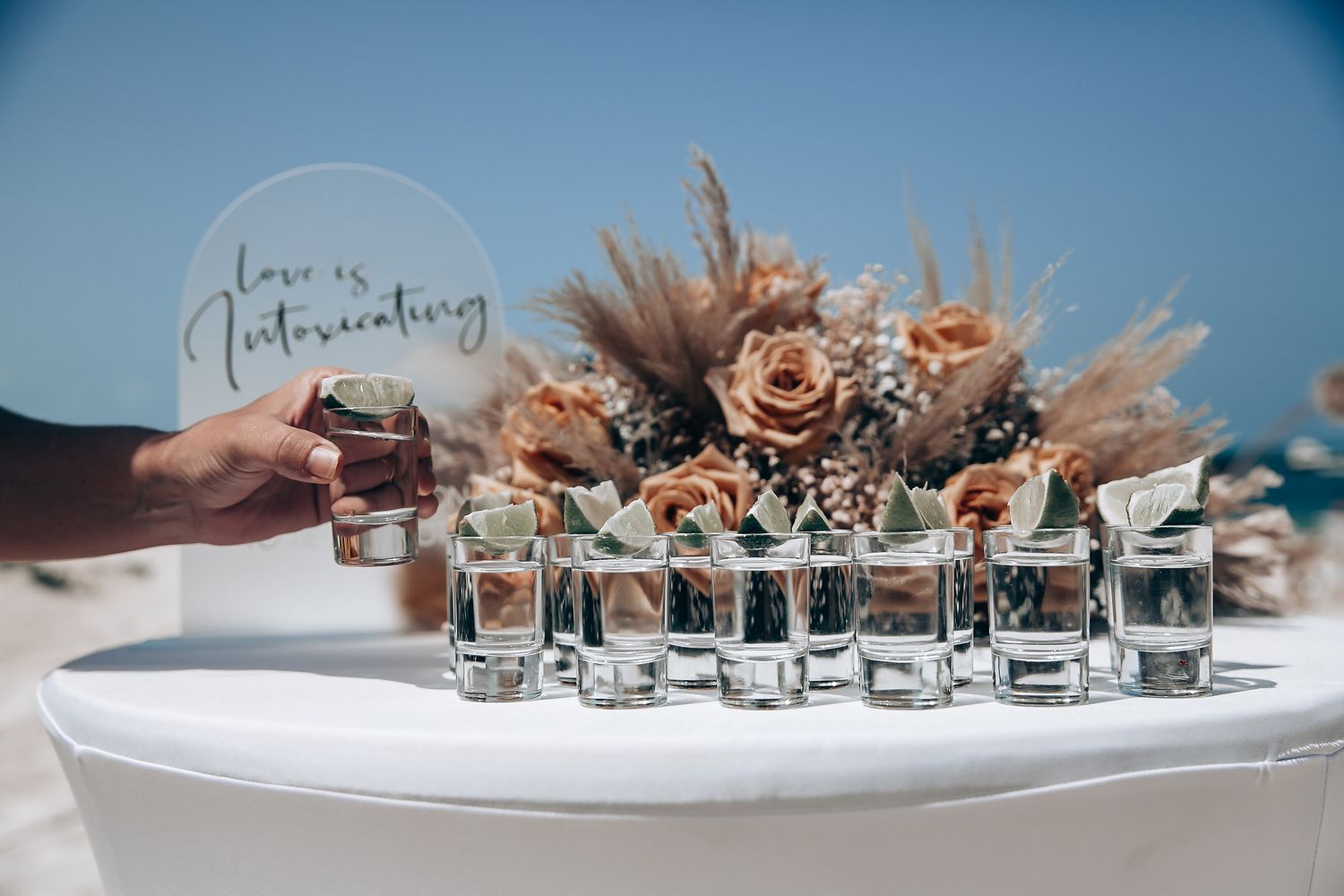 Wedding rings and jewelry arranged artistically on a white surface with decorative elements.