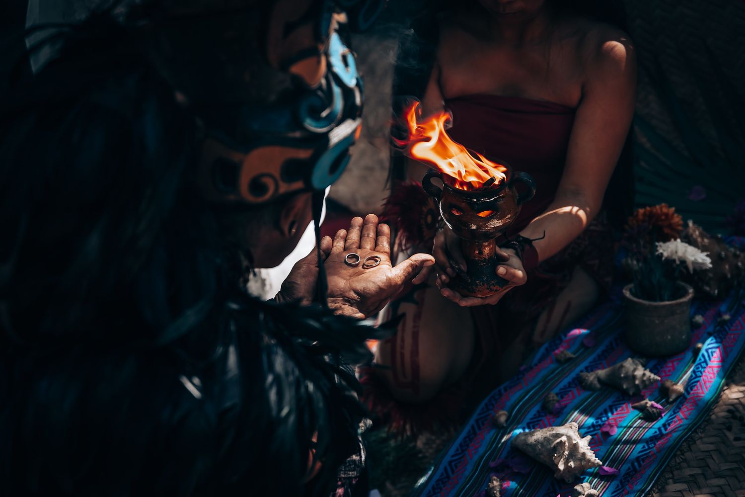 Nighttime spiritual ceremony with fire and traditional elements in dark atmospheric setting.