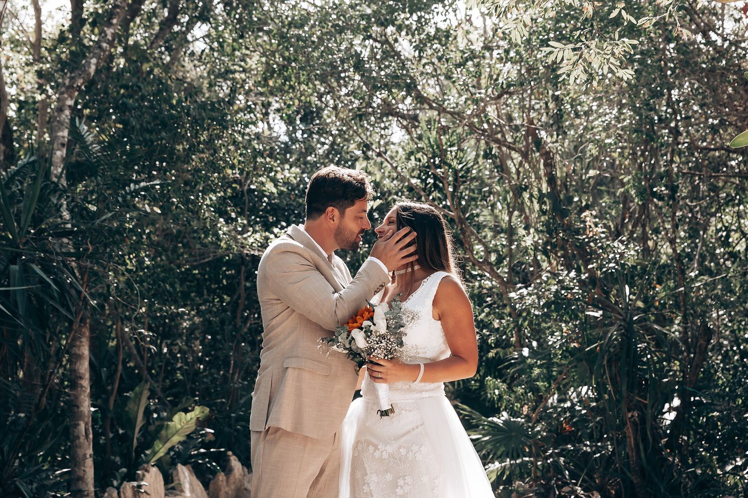 Intimate ceremony moment captured in a sunlit tropical forest setting.