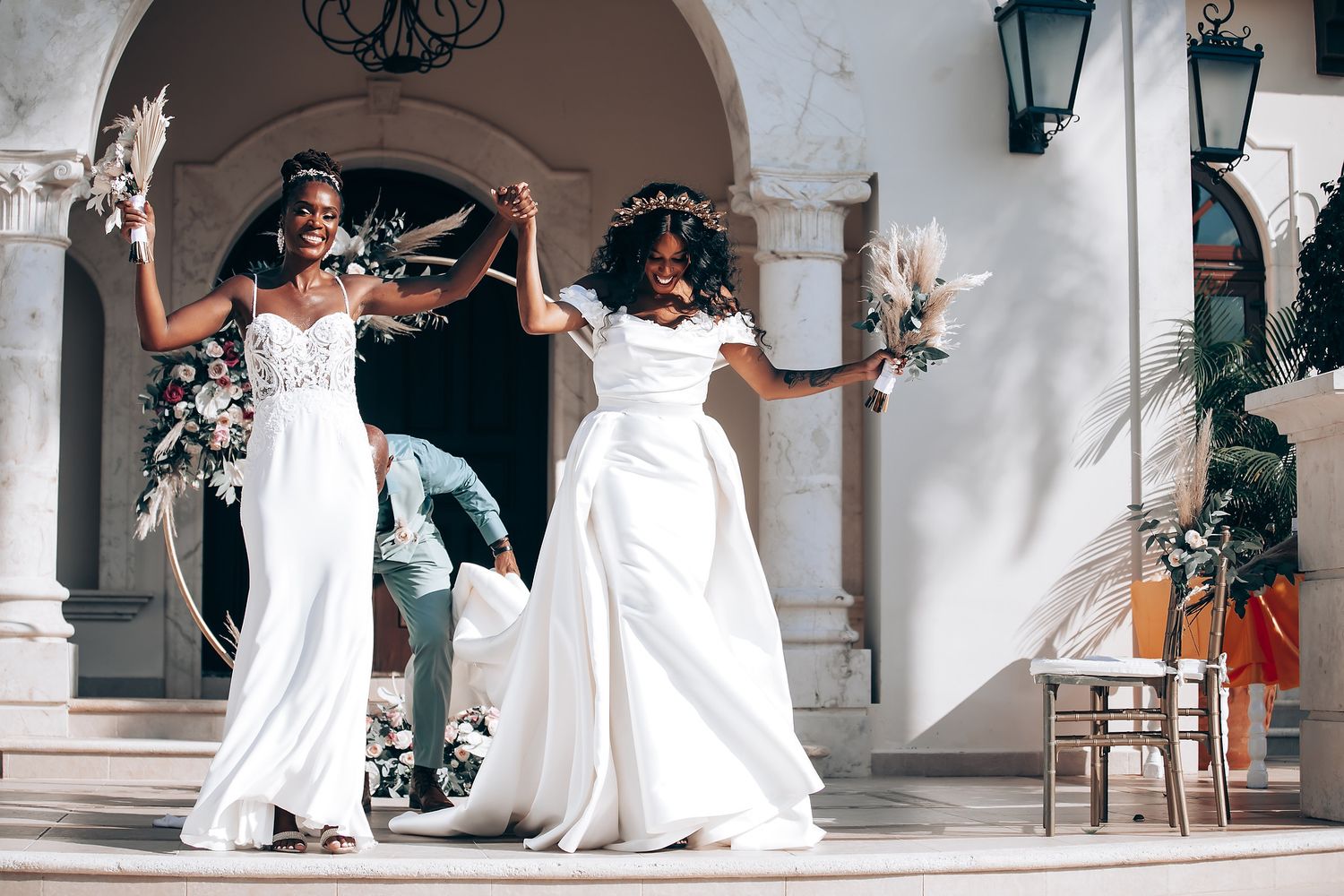 Wedding ceremony setup with white decor and floral arrangements in an elegant courtyard.