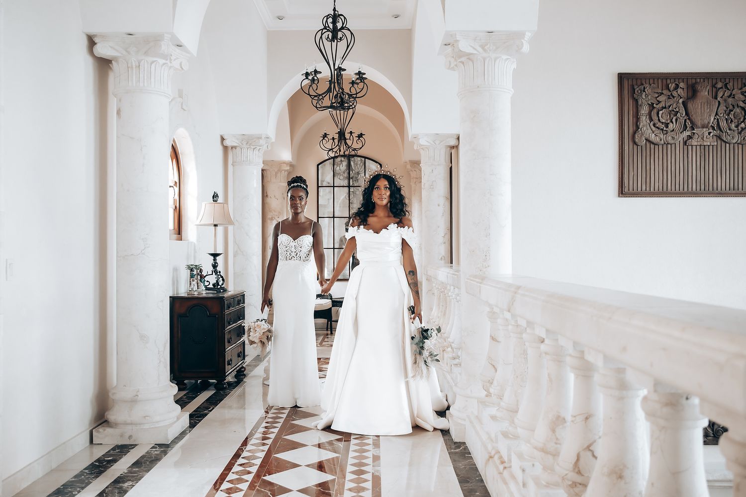 Elegant white colonnade hallway decorated for a wedding with hanging lanterns and archways.